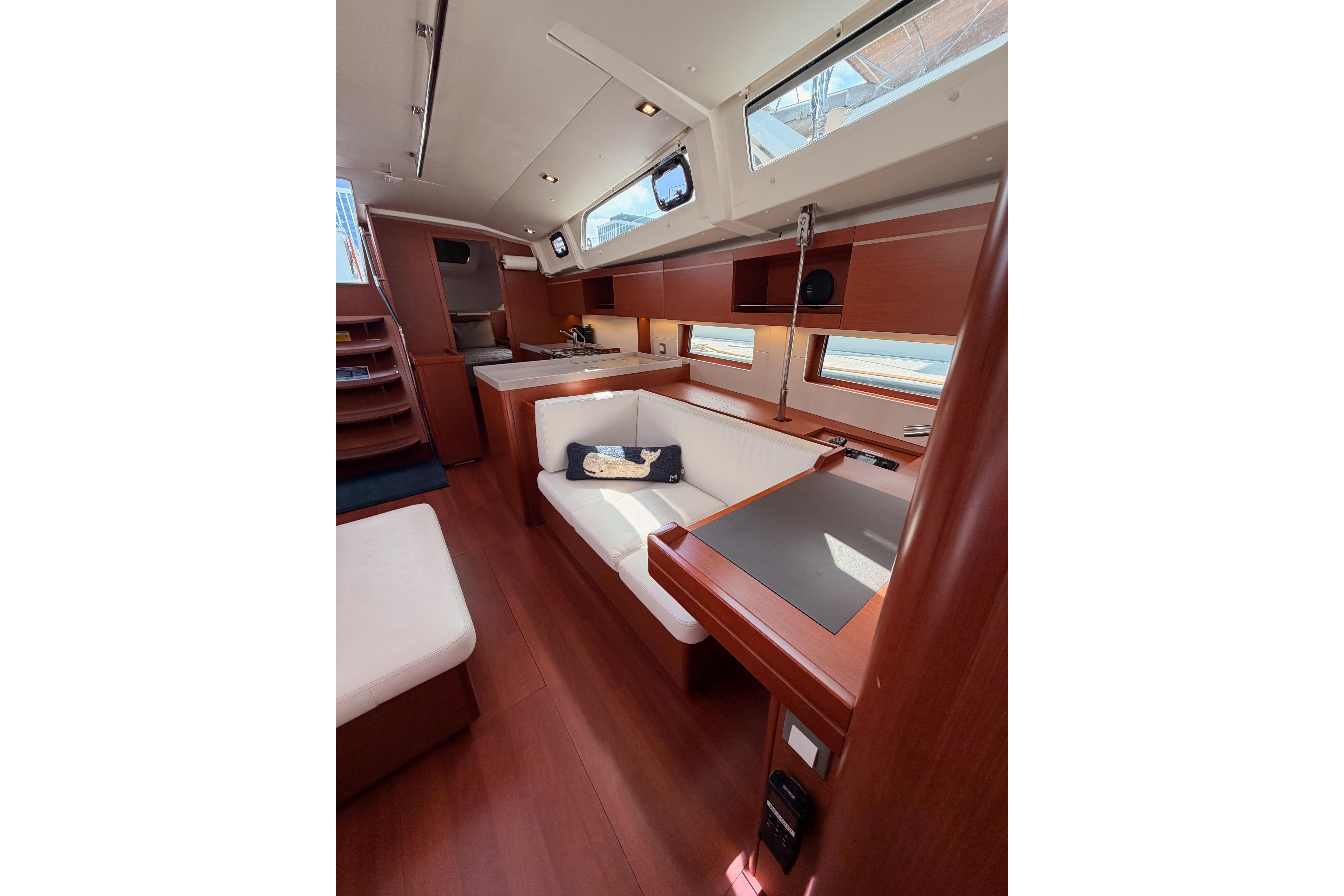 Interior of 2020 Beneteau Oceanis 46.1 yacht, featuring elegant wood finishes and modern seating.