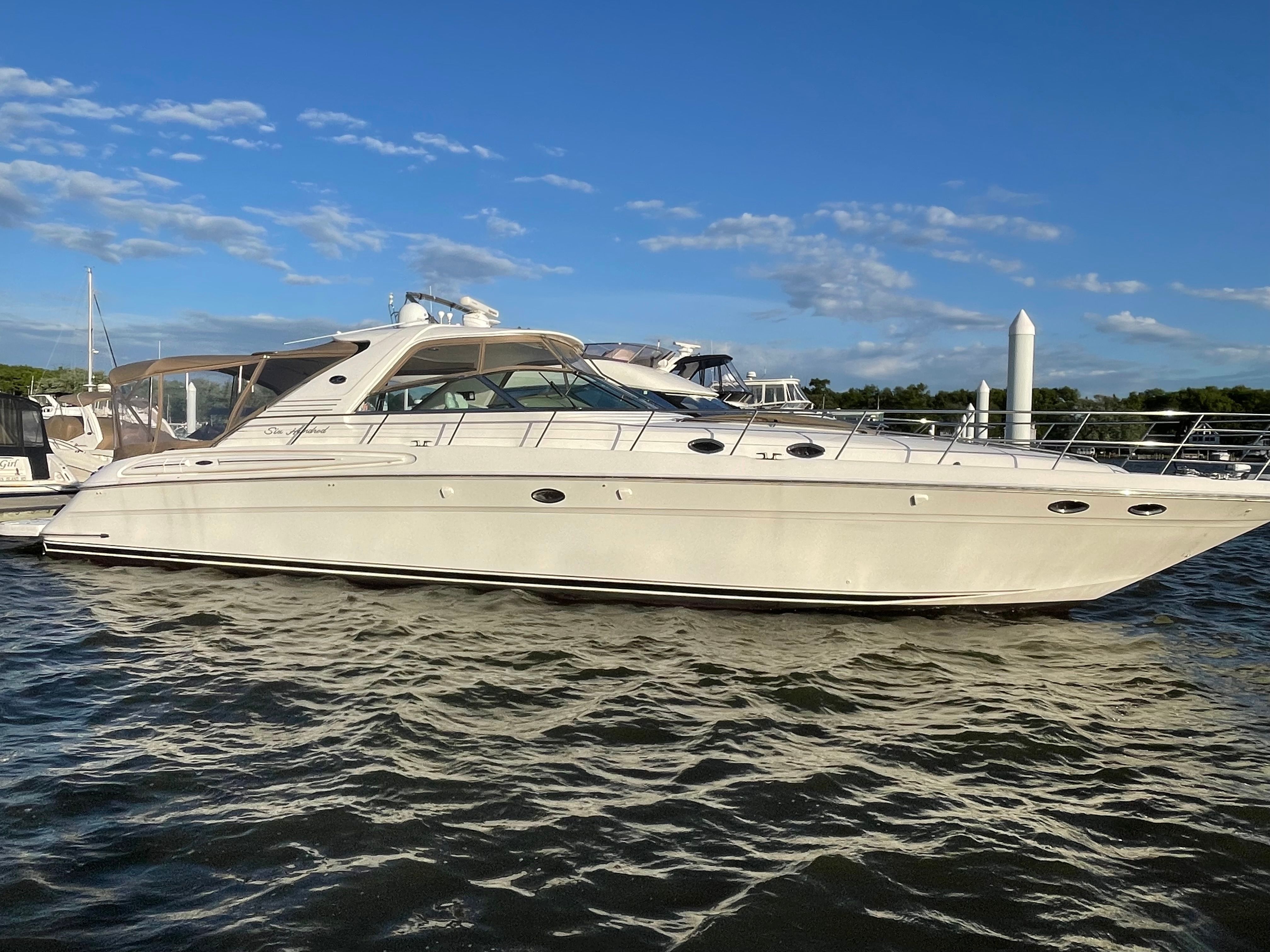 A 2003 Sea Ray S600 Sunsport is on the water, surrounded by other boats.