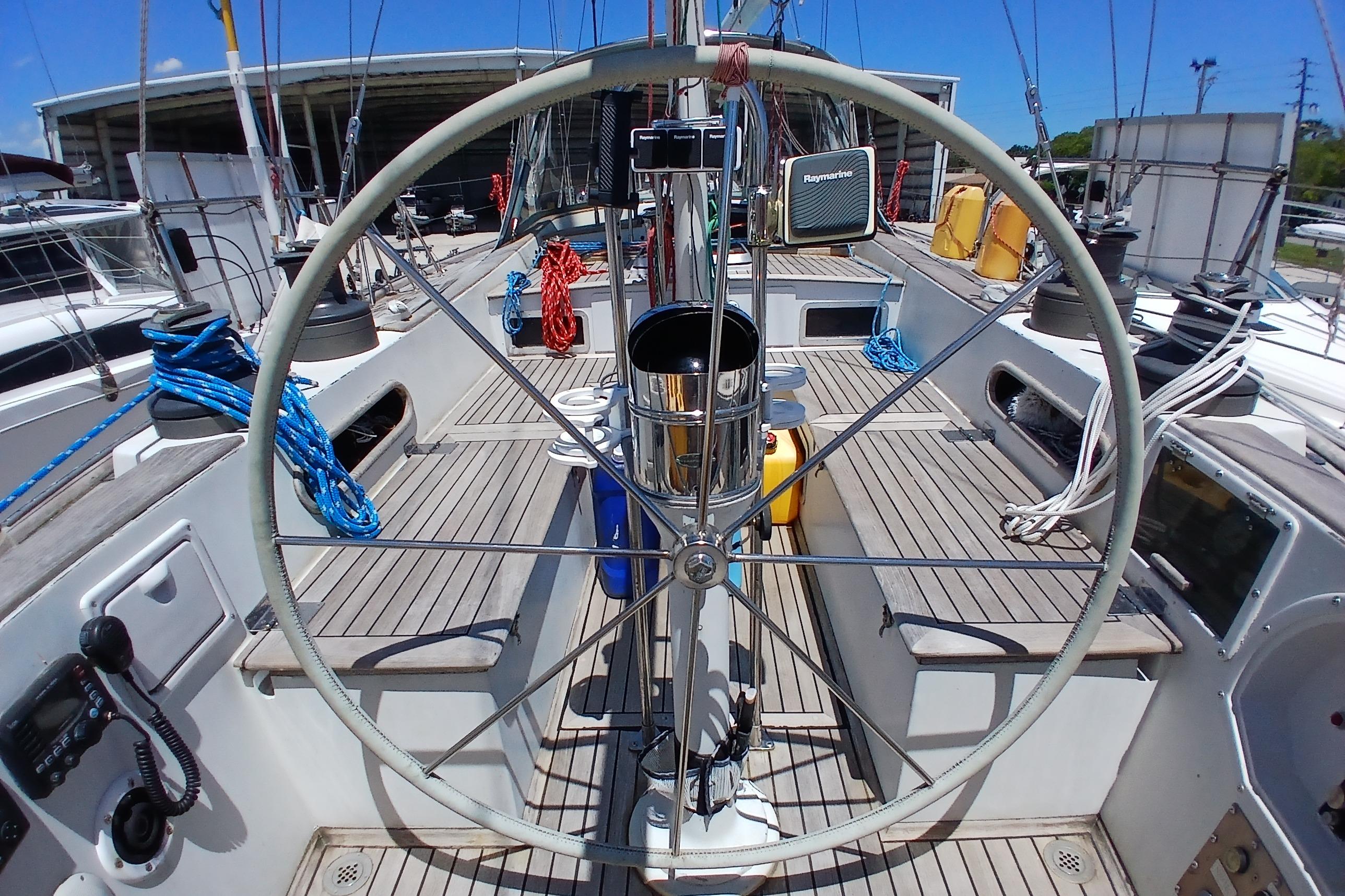 Cockpit view of 1981 Kaufman Skye 51 sailboat with steering wheel and nautical equipment.