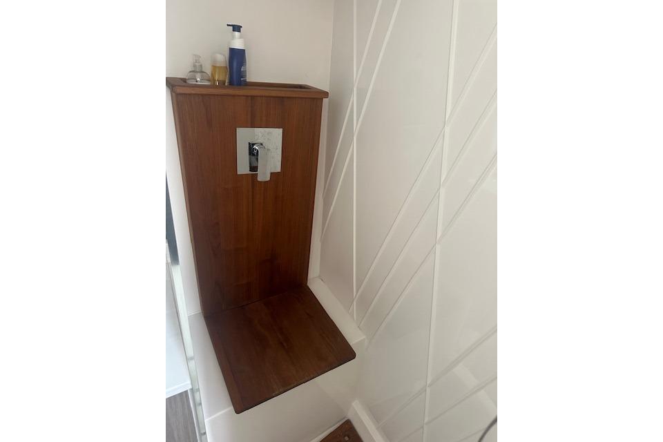Wooden shower seat in 2022 Regal 38 SAV boat bathroom.