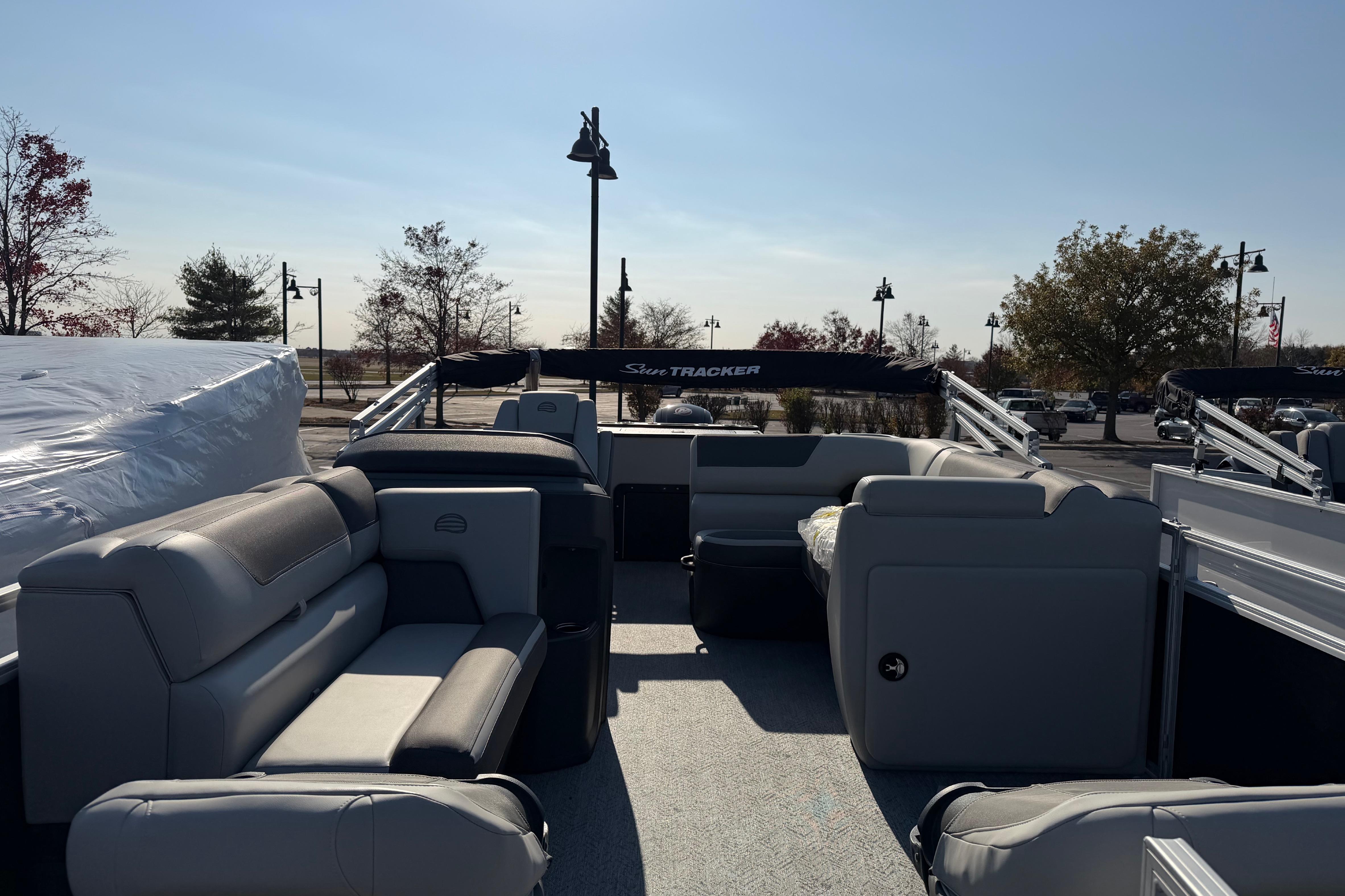 2026 Sun Tracker Fishin' Barge 20 DLX pontoon boat with spacious seating and outdoor setting.