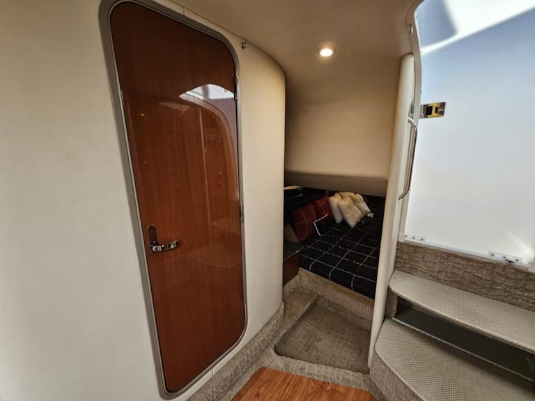 Interior cabin of a 2007 Formula 400 Super Sport boat with wooden door and cozy bed.