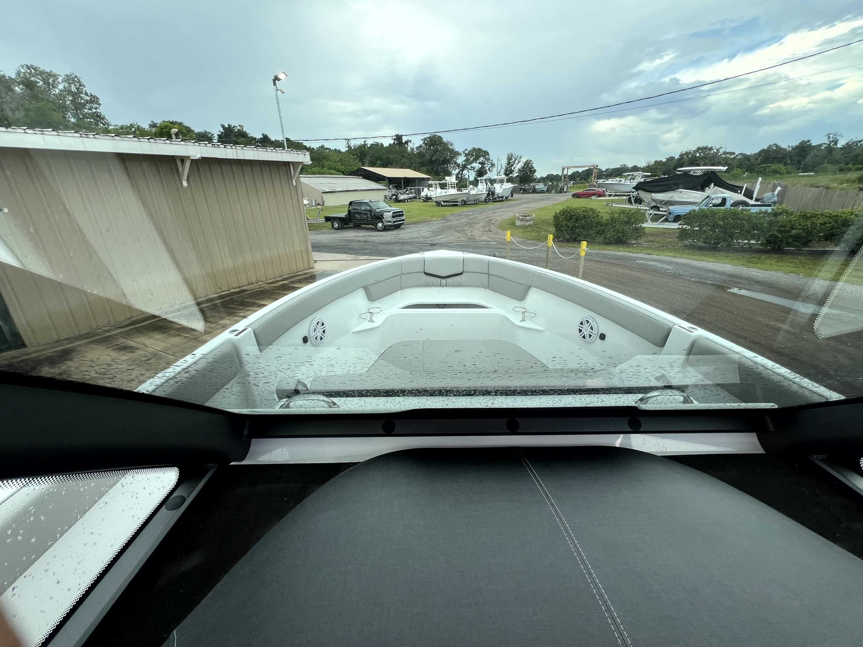 View from the cockpit of a Monterey Elite 25 boat's bow, surrounded by buildings and trees.