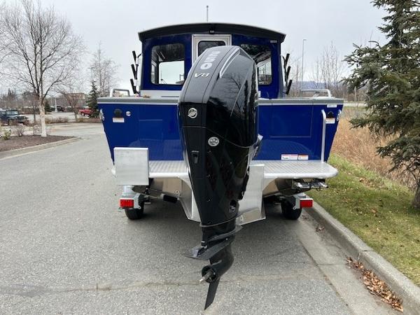 2023 Spartan 220 Maximus Pro boat with powerful V8 engine, parked on a road.
