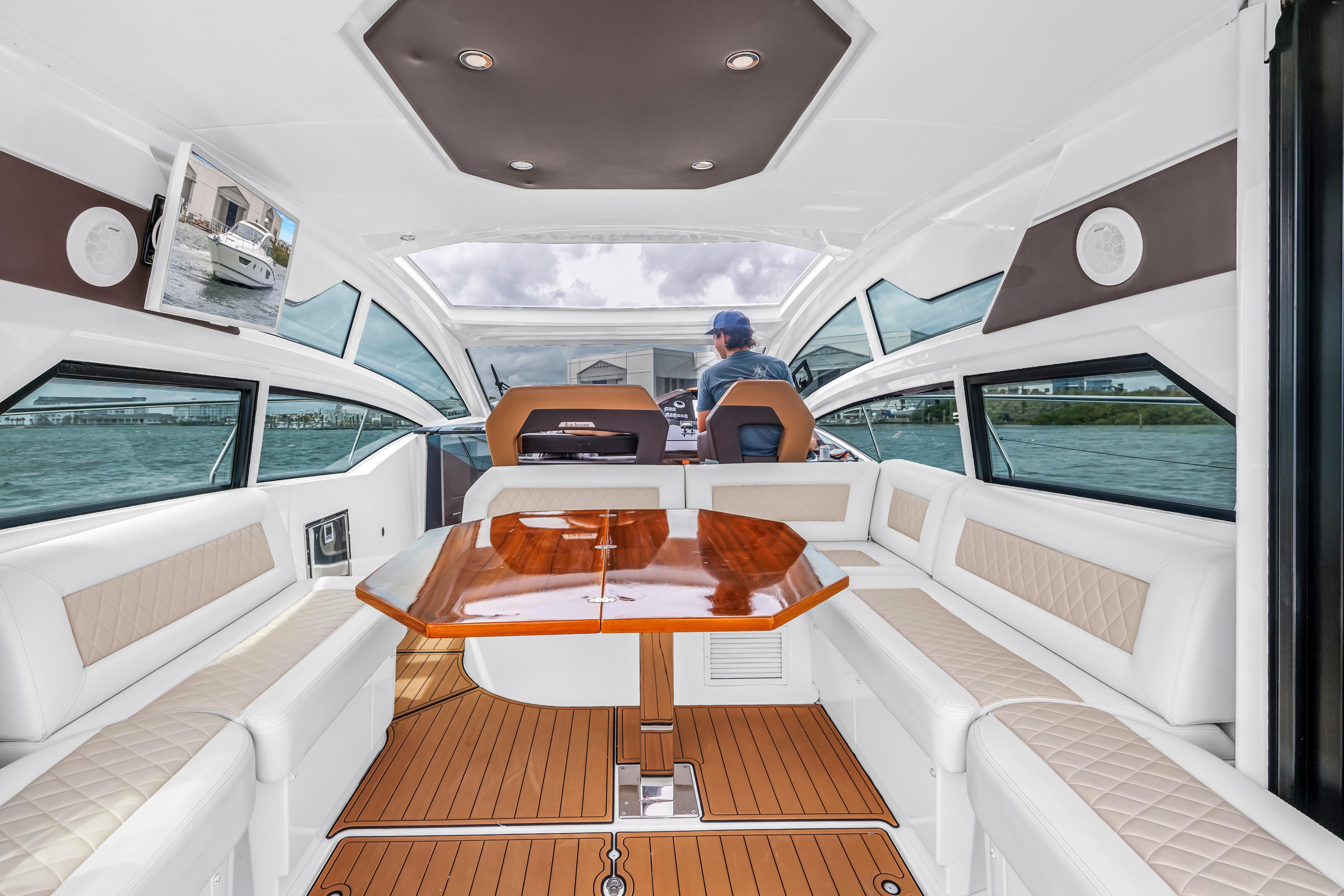 Luxurious interior of 2019 Beneteau Gran Turismo 46 yacht with elegant seating and wooden table.