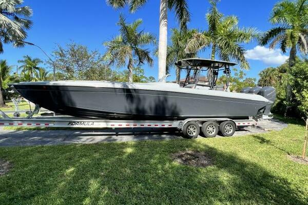 1996 Formula 382 SR1 boat on trailer, surrounded by palm trees and clear blue sky.