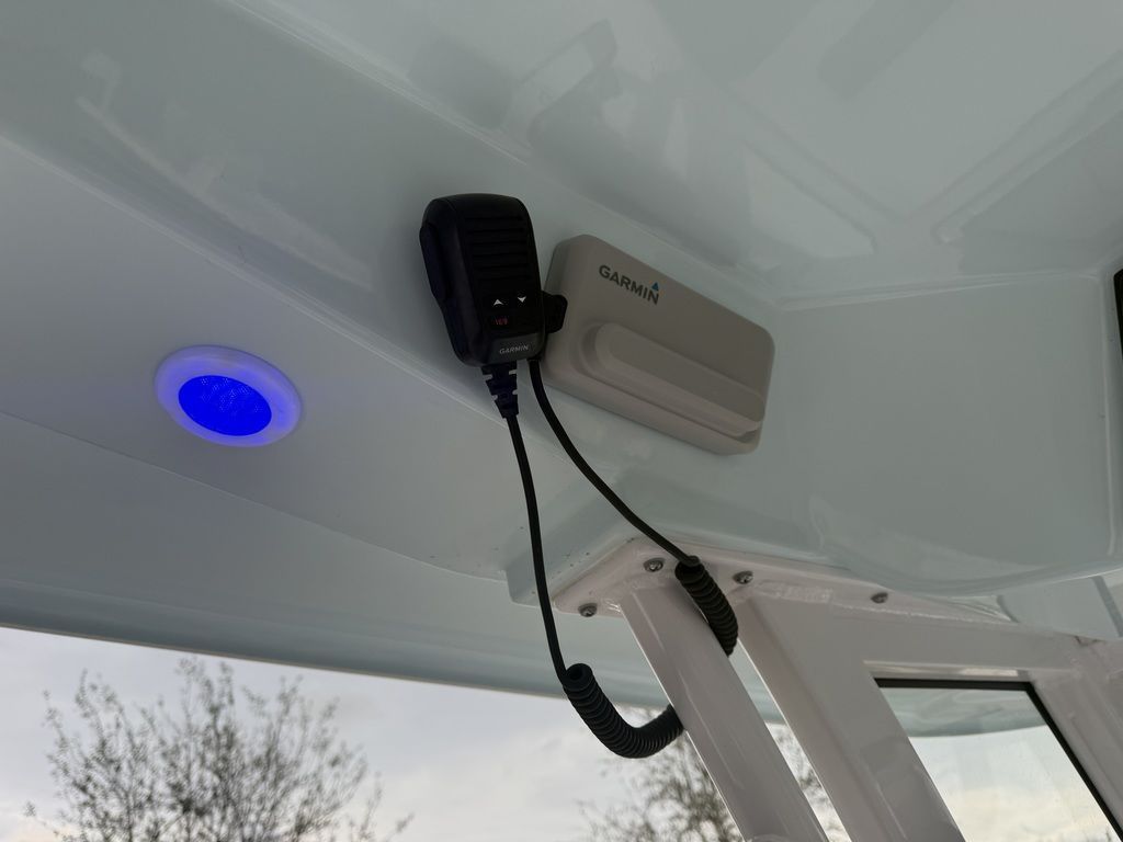 A microphone and a Garmin device are mounted on a boat's ceiling.