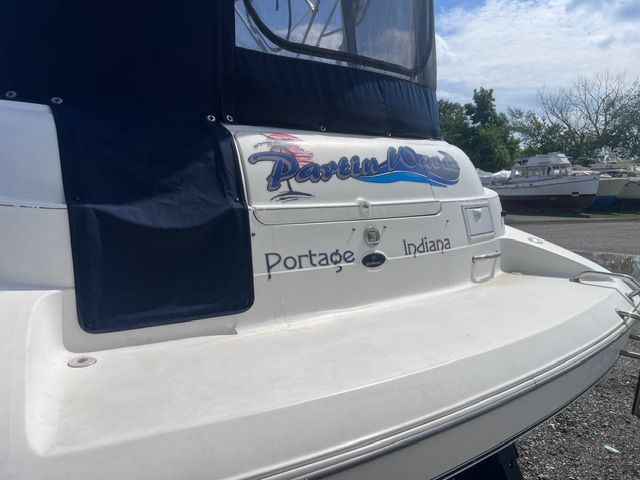 The image shows the stern of a 1999 Doral 300sc boat with a blue cover.