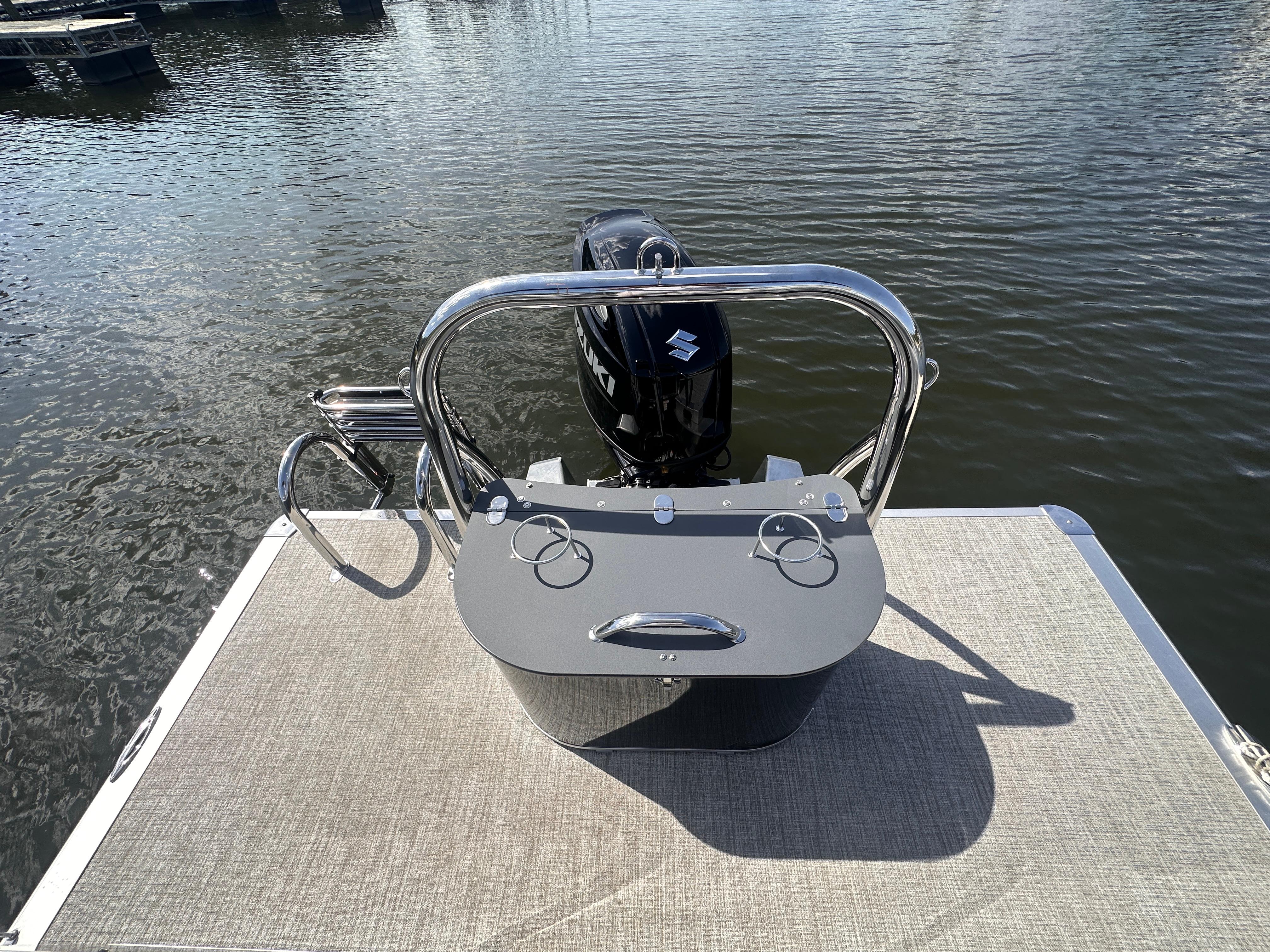 2025 Avalon LSZ Quad Lounger boat with Suzuki motor on calm water.