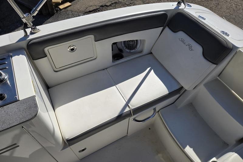 Interior seating of 2011 Sea Ray 300 Sundeck boat, featuring white cushions and storage compartments.