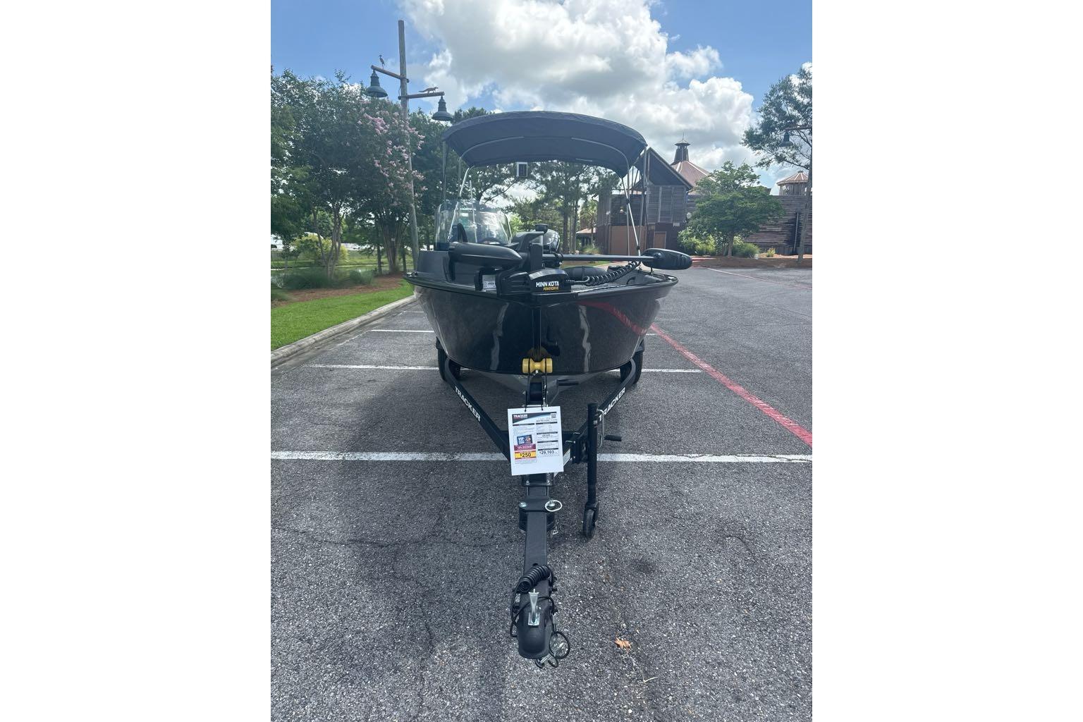 2026 Tracker Pro Guide V-16 SC boat parked outdoors under a cloudy sky.