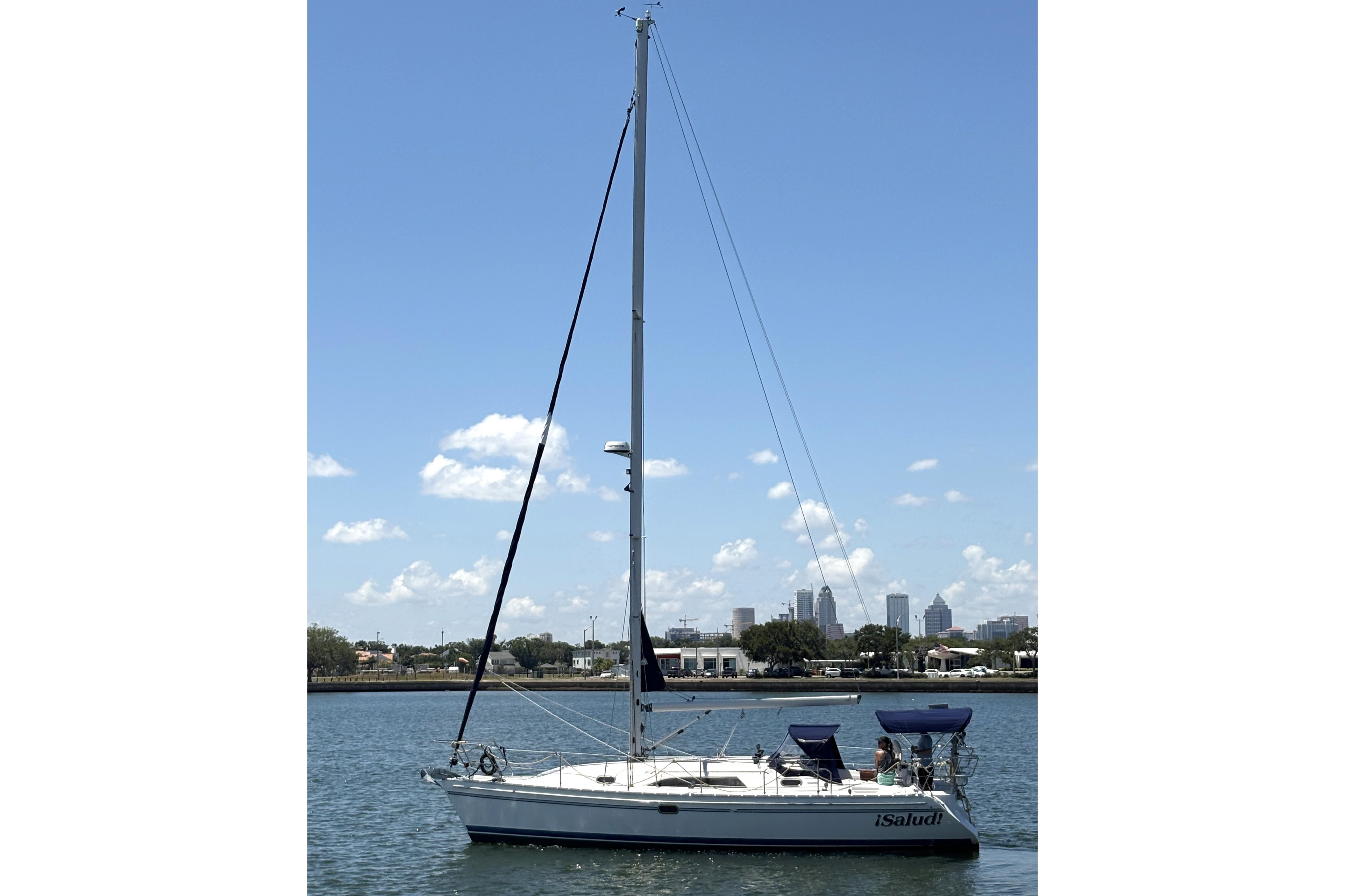 2011 Catalina 355 sailboat on calm water with city skyline in background.