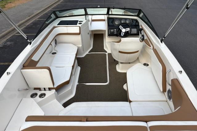 2017 Searay SPX210 boat interior with brown and white seating, steering console, and spacious layout.