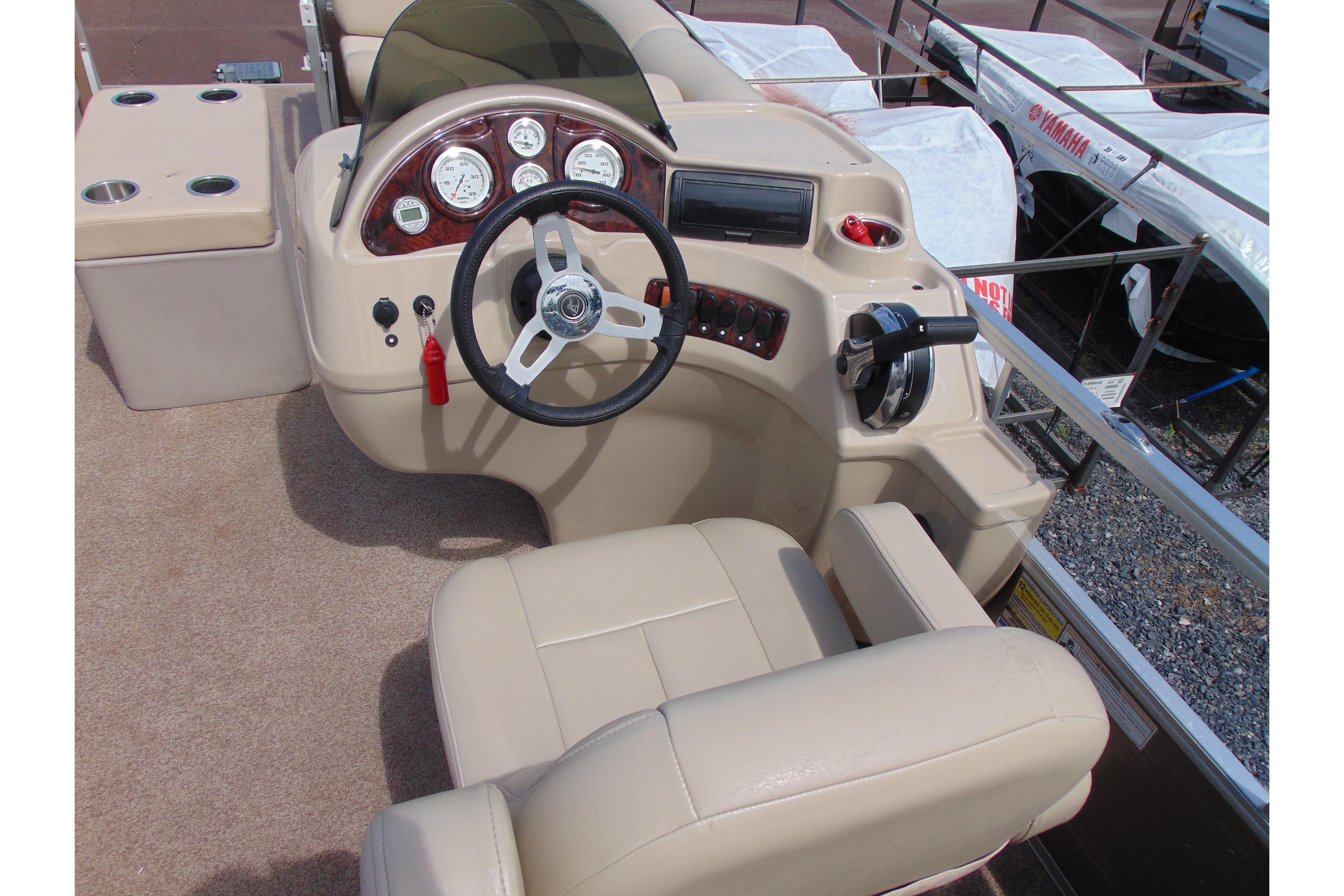 2016 Misty Harbor 245 Adventure CU boat helm with beige seating and control panel.