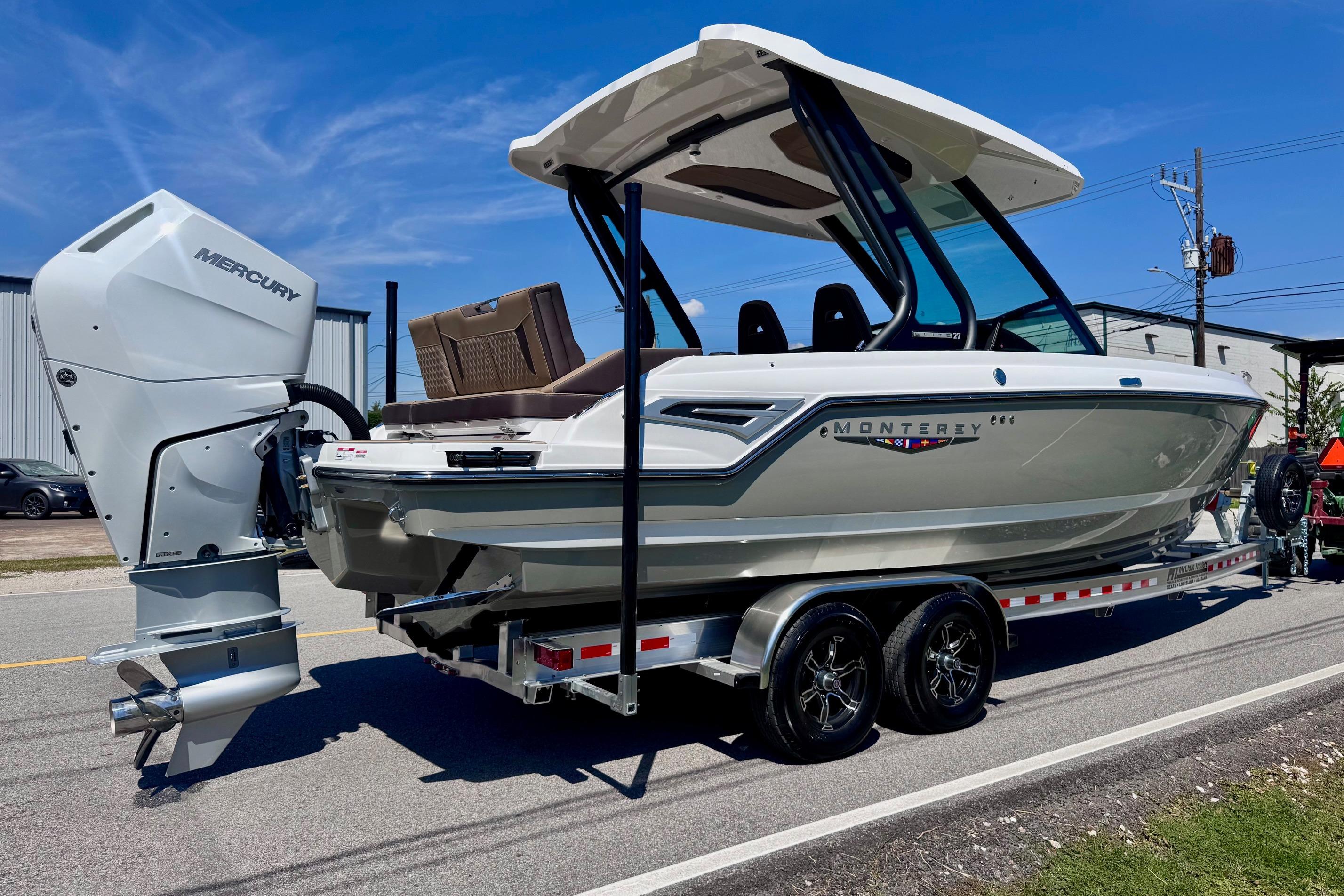 2026 Monterey Elite 27 OB boat on trailer, featuring Mercury outboard motor, parked on street.