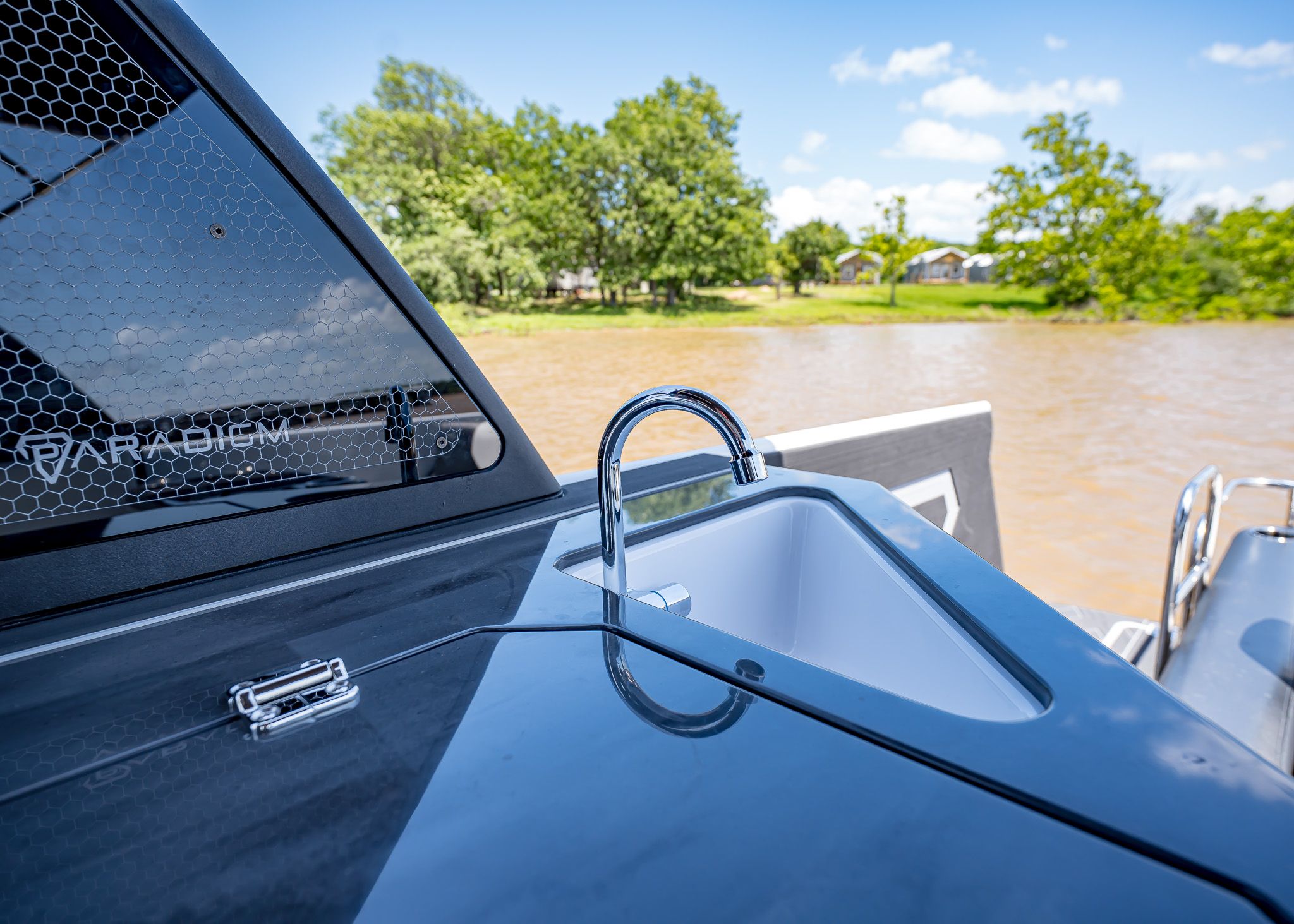 Paradigm 266 SL SURF boat with sink, river landscape in background.