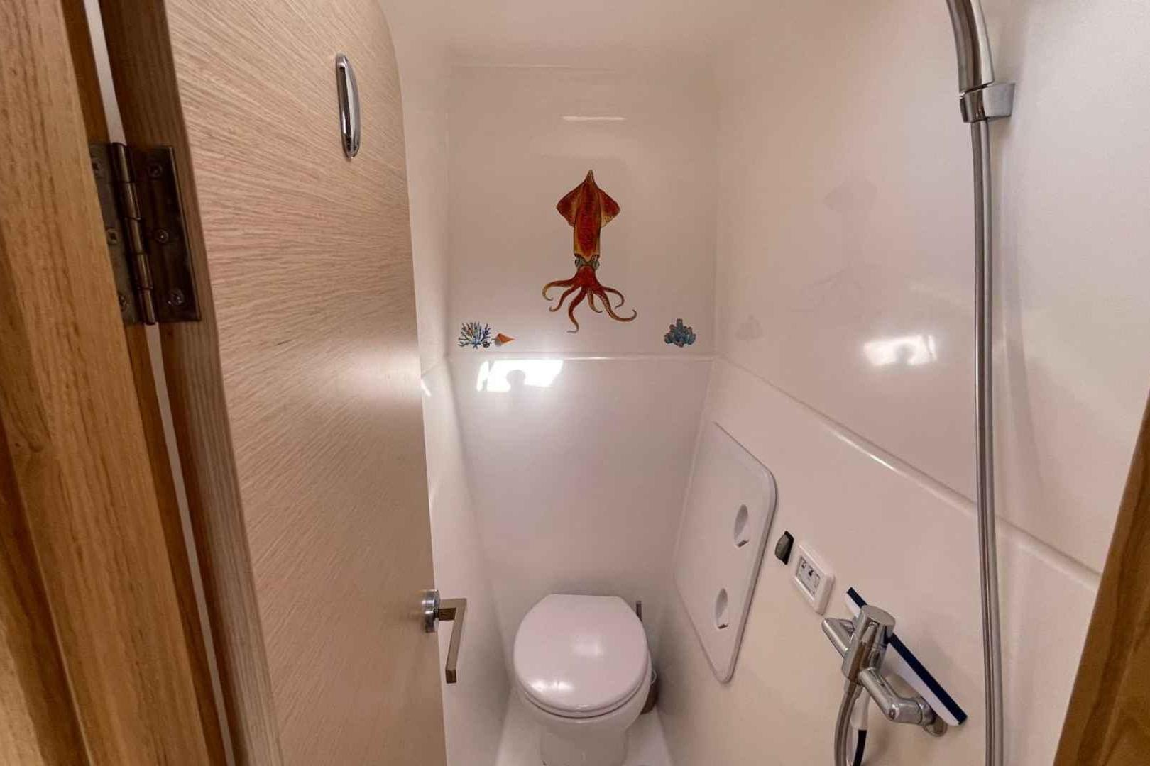Compact bathroom in 2023 NEEL 51 with squid wall art and modern fixtures.