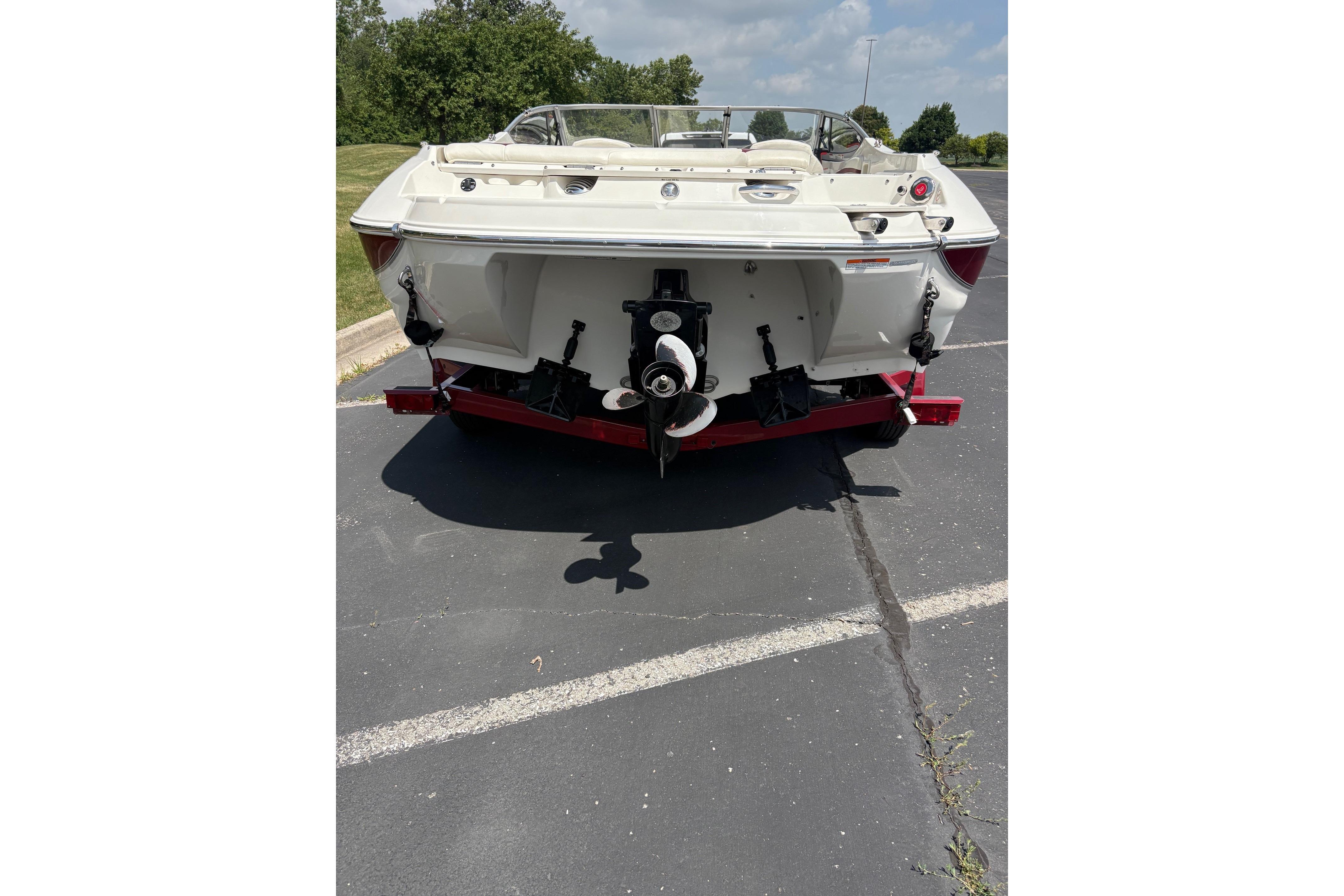 2013 Stingray 198 LX boat rear view on pavement, showcasing outboard motor and sleek design.