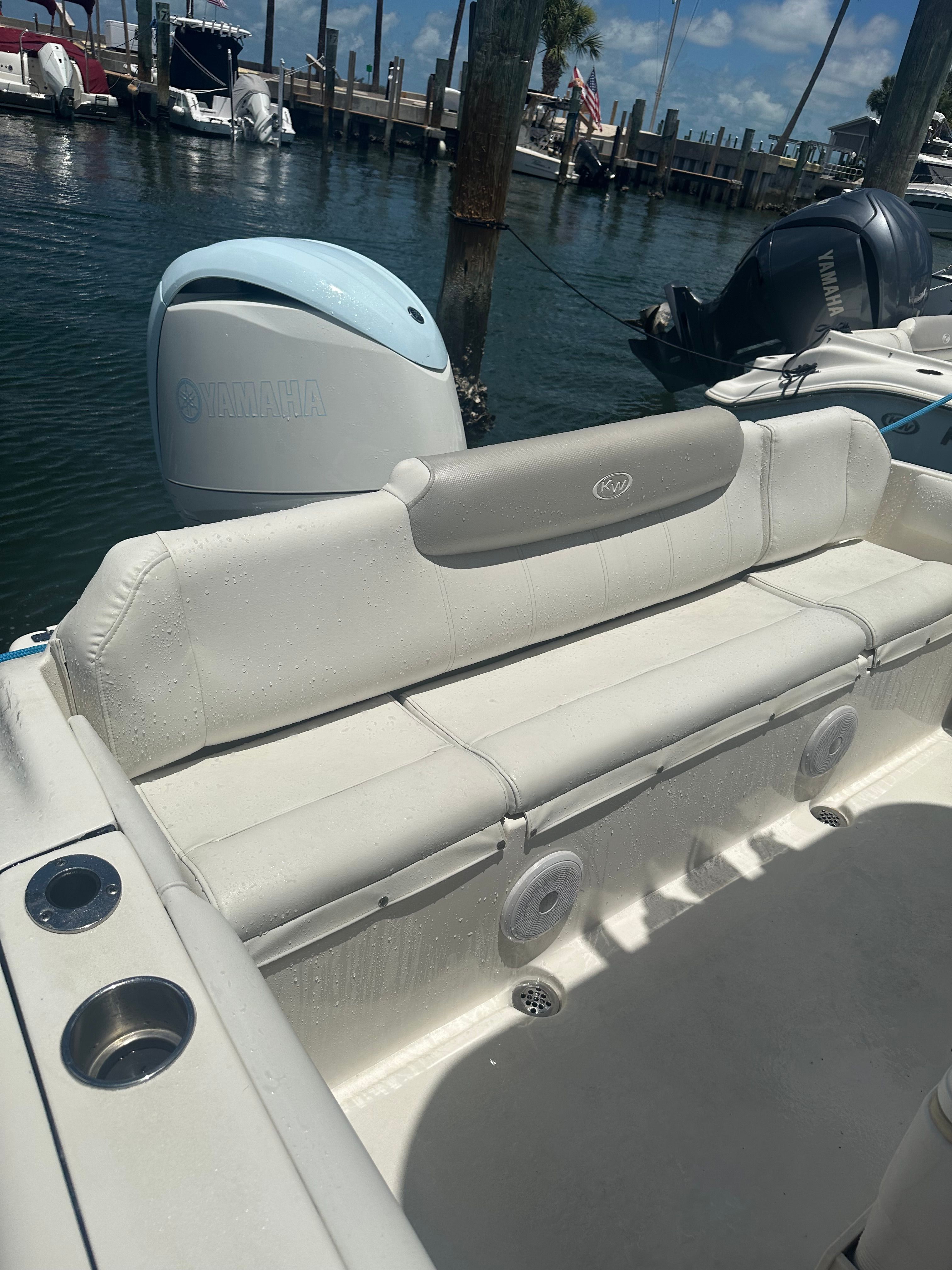 A Key West 219 FS boat with white seating at the dock.