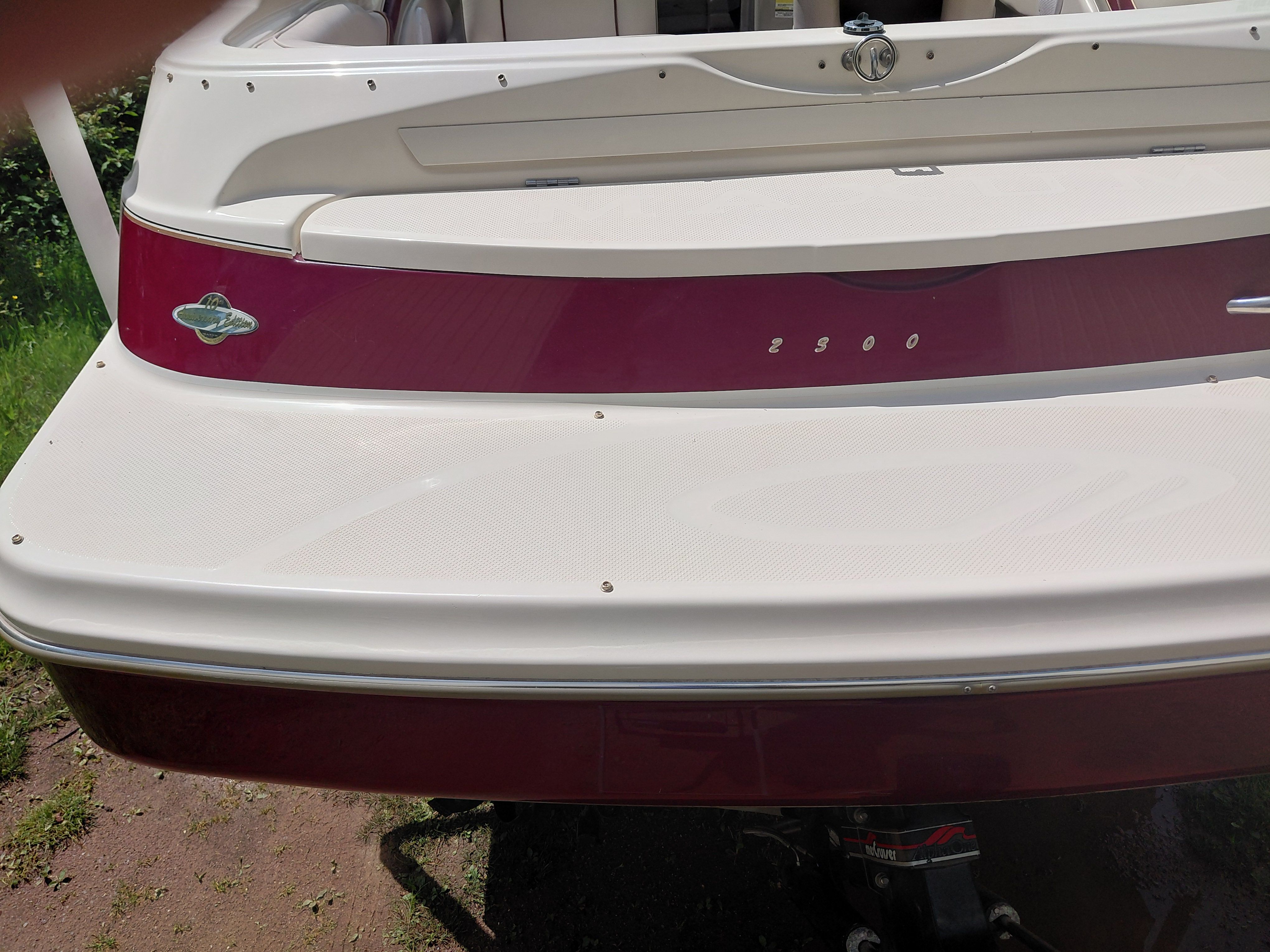 The image shows the stern of a 1997 Maxum 2300 SC boat with a red and white design.