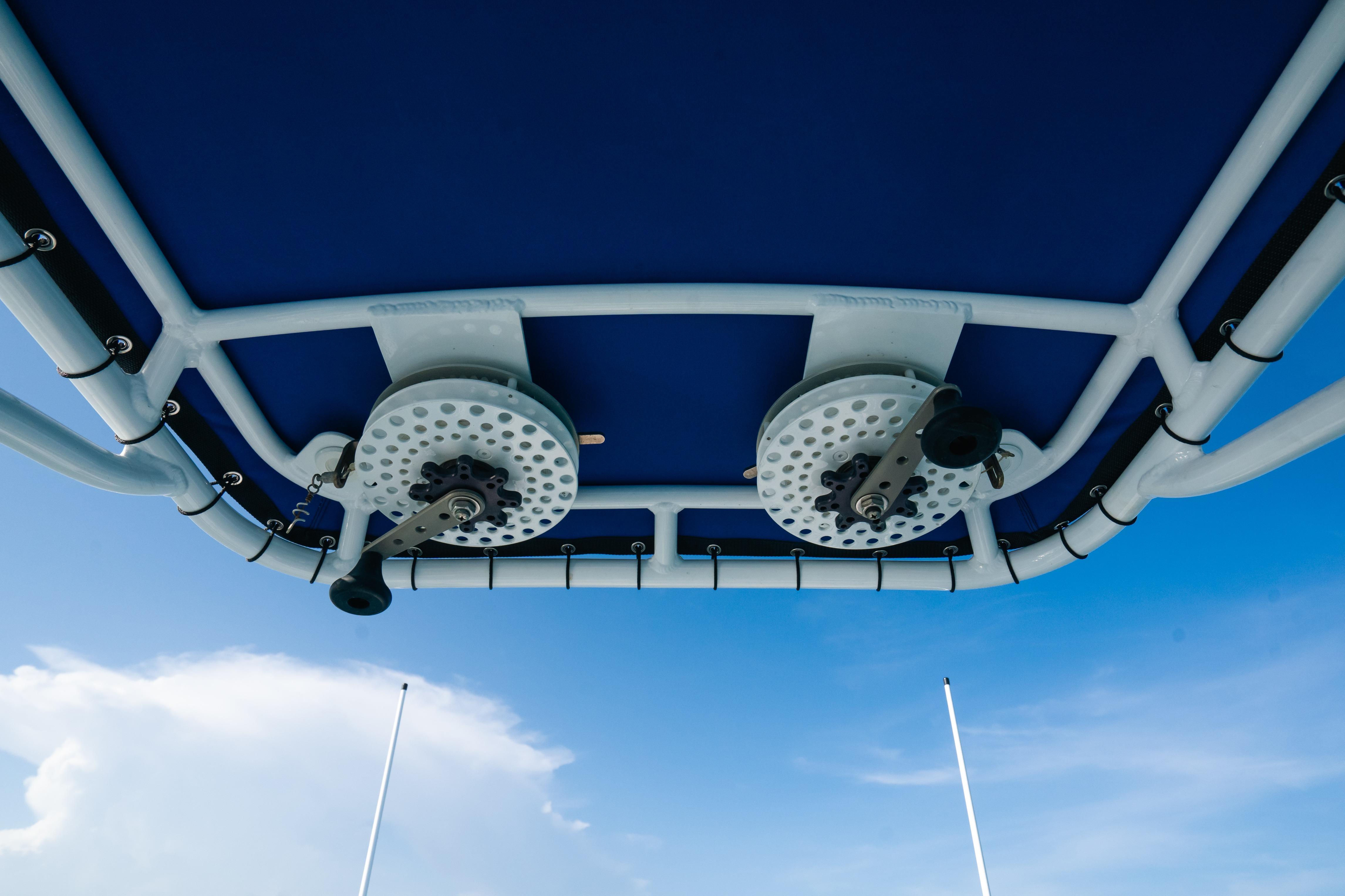 2022 Nor-Tech 392 Super Fish boat canopy with fishing rod holders against blue sky.