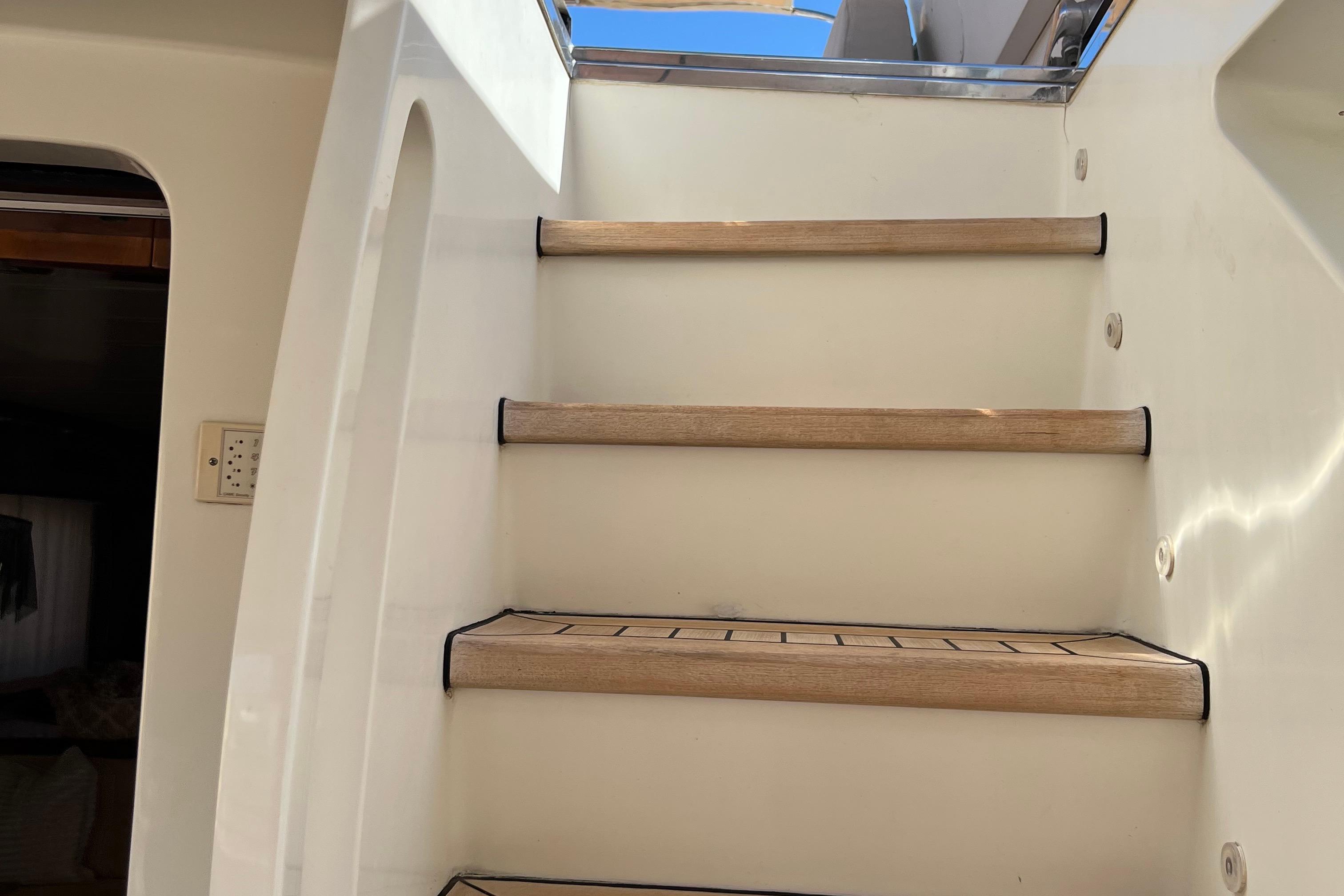 Staircase on a 2001 Maiora 24 yacht, featuring wooden steps and sleek design.