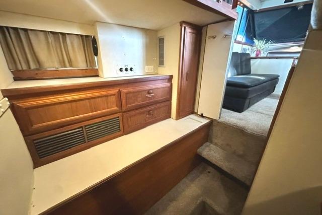 Interior of 1989 Carver 32 Aft Cabin Motor Yacht with wood cabinetry and carpeted steps.