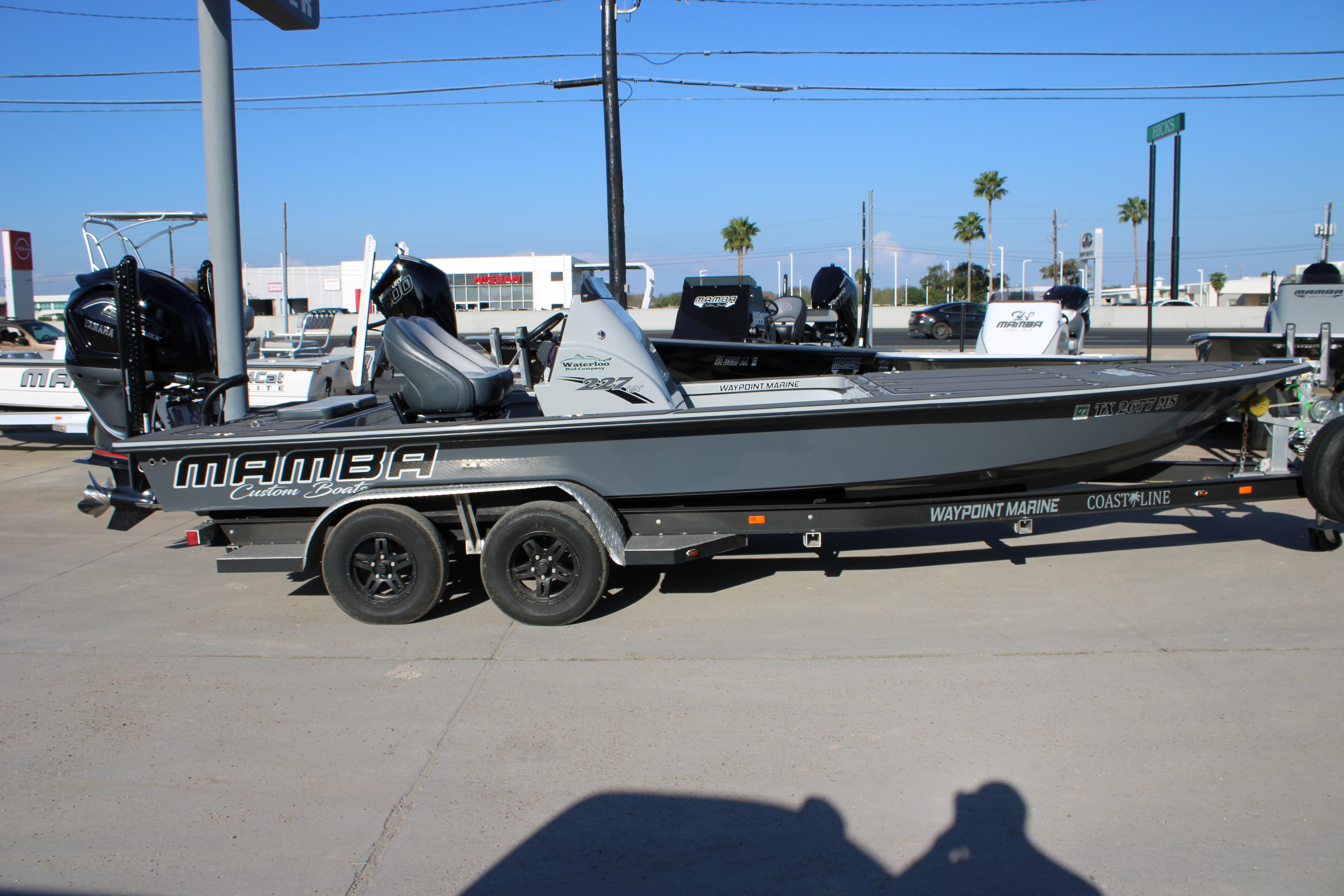 2025 Mamba 227VX boat on trailer at dealership, showcasing sleek design and branding.
