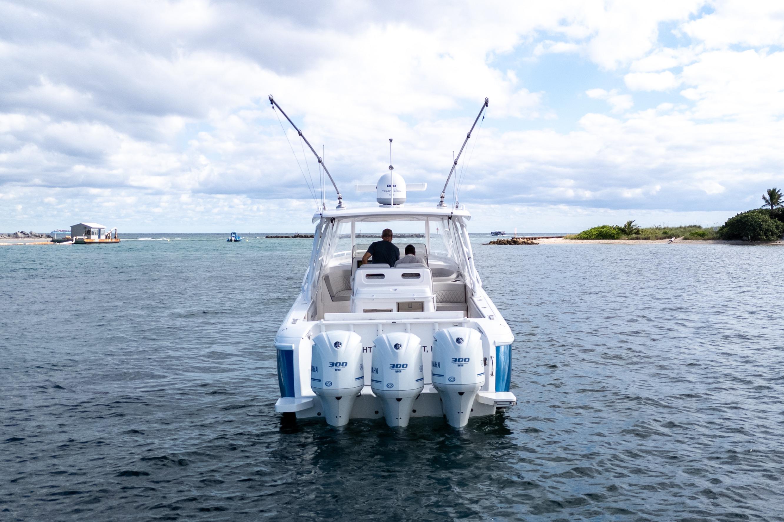 2019 Intrepid 407 Cuddy boat on water, featuring triple outboard engines.