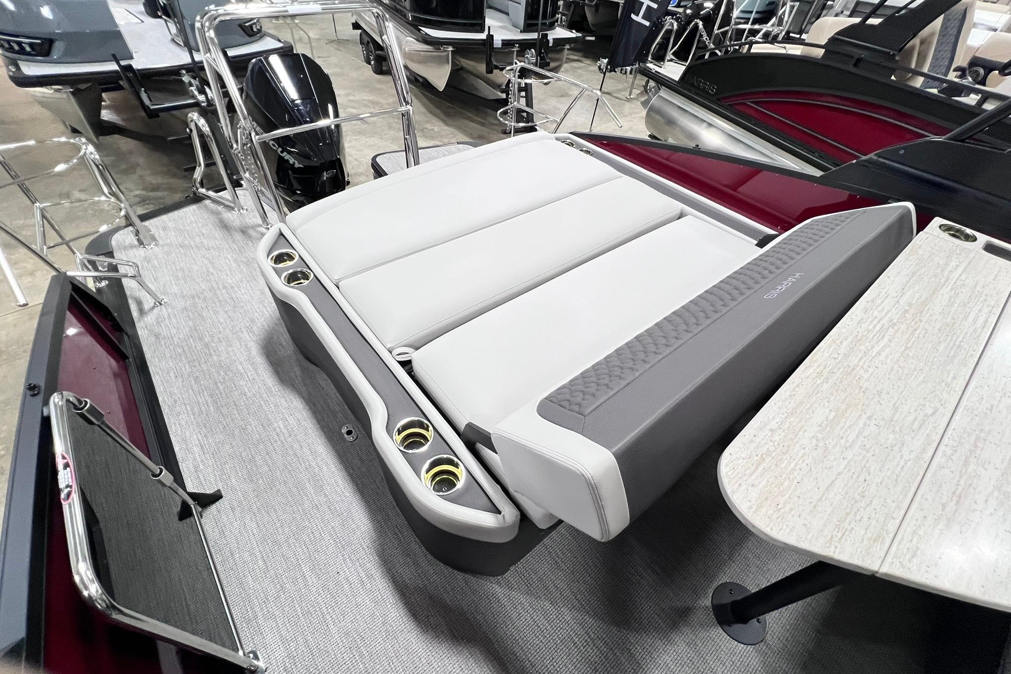 2026 Harris Sunliner 250 SLE boat interior with seating and table, showcasing modern design.