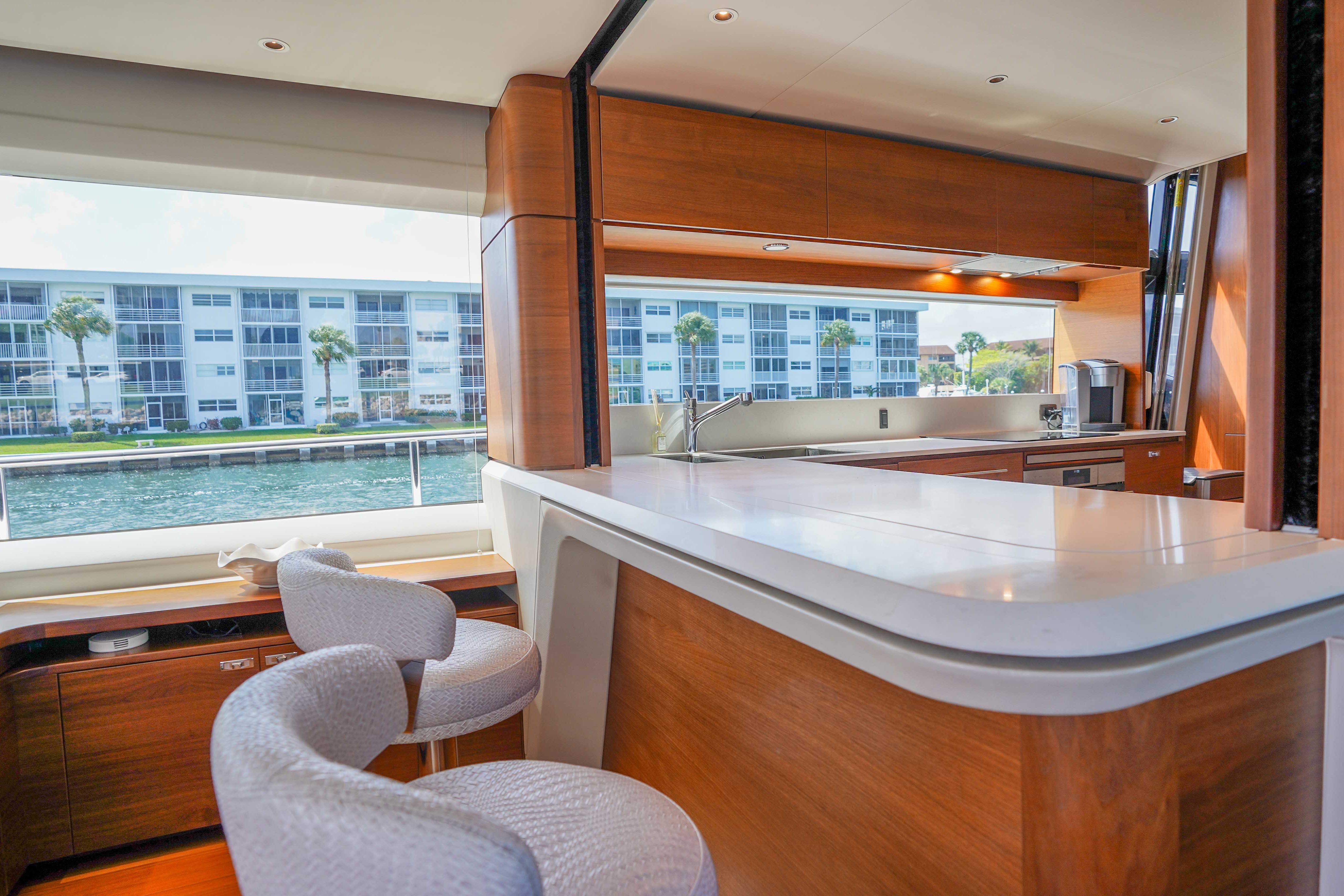 Luxurious interior of 2021 Princess Y85 yacht with modern kitchen and waterfront view.