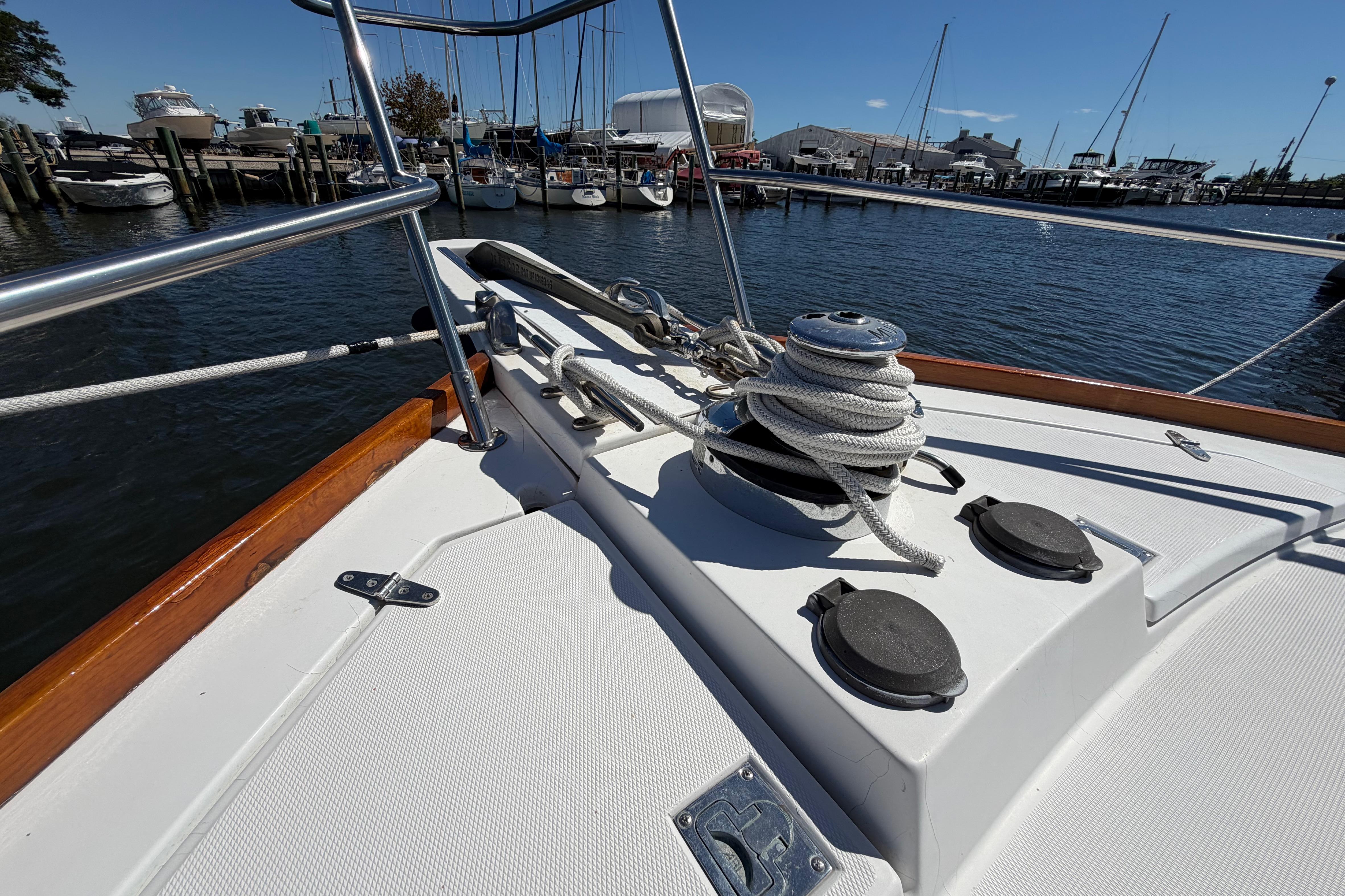 Bow of 2000 Sabreline 36 Express yacht with ropes and winch in marina.
