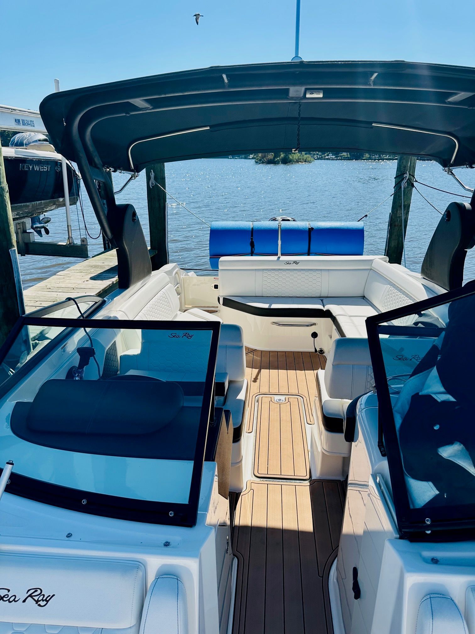 A 2018 Sea Ray SDX 270 Outboard docked. It features an open deck and a sunshade.