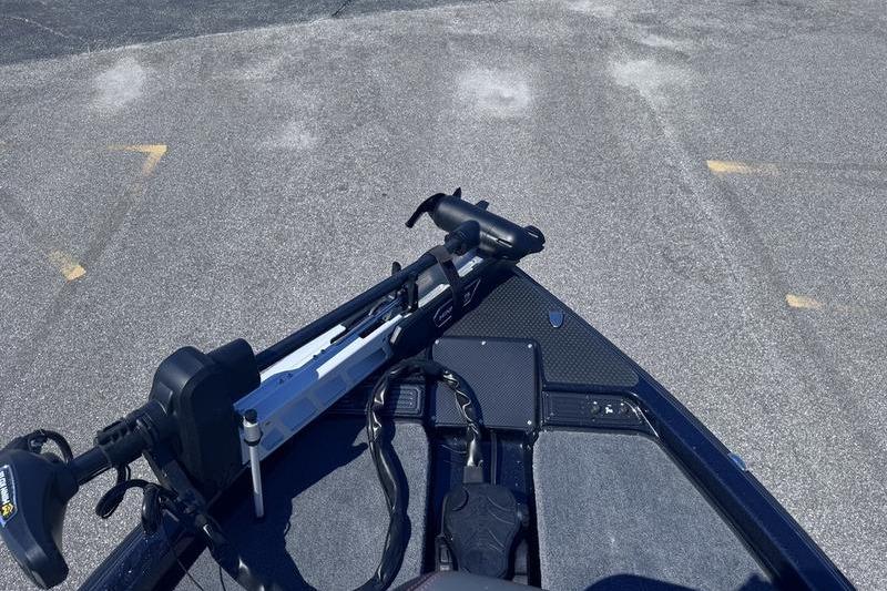 2026 Phoenix 819 ZXL boat deck with mounted trolling motor on asphalt surface.