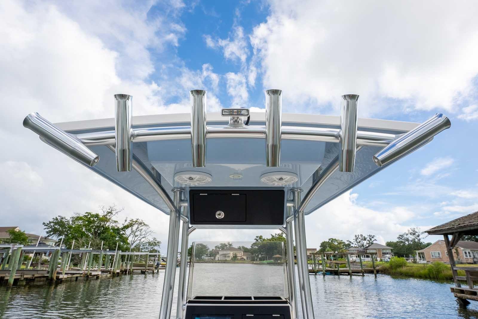 Bay Rider 219 Bay 2026 boat with rod holders, docked under a blue sky.