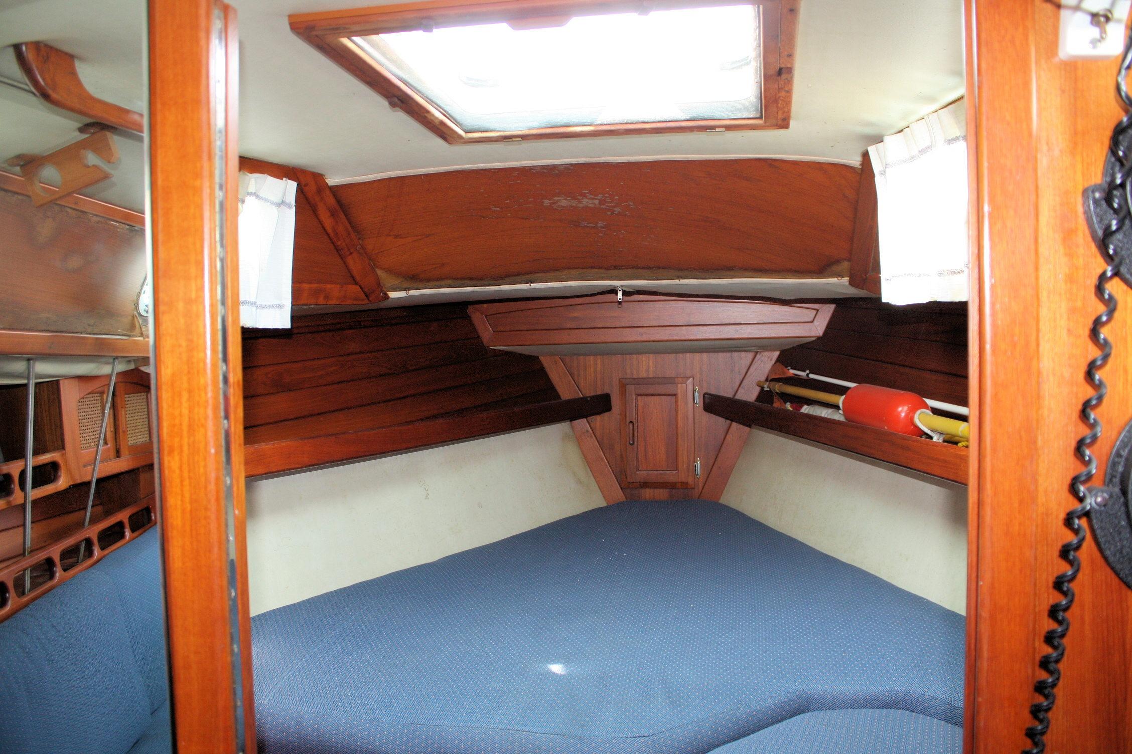 Cozy cabin interior of 1987 Ericson 38-200 sailboat with wooden finish and skylight.
