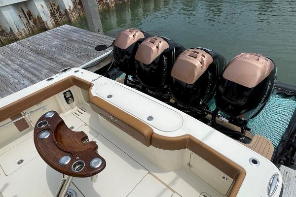 2020 Scout 420 LXF boat with four powerful outboard engines docked at a marina.