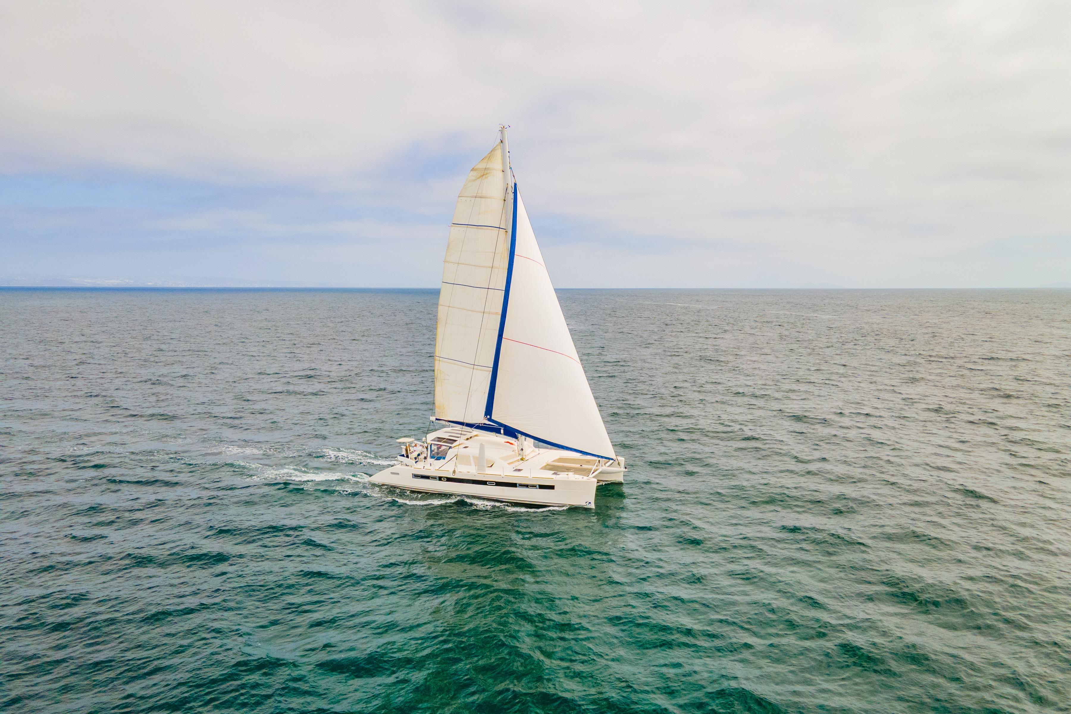 Sailing Catana 65 catamaran from 2009 gliding on open ocean waters.
