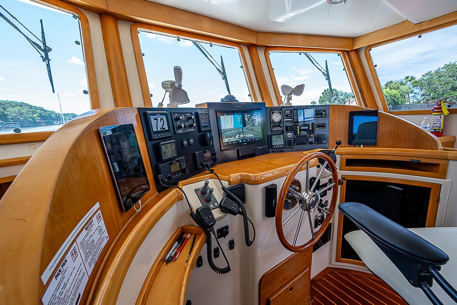 Helm of 2003 Magna Marine Nova Scotia 47, featuring navigation instruments and wooden steering wheel.