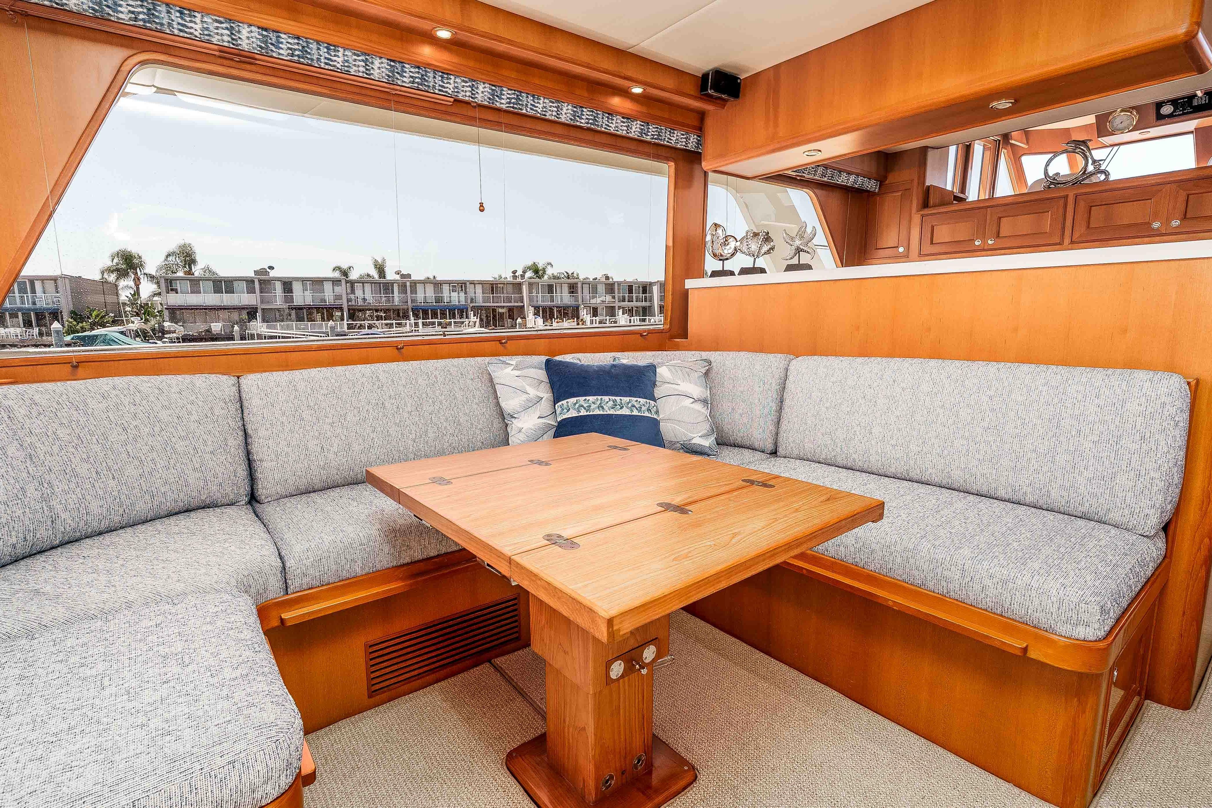 Luxurious interior of 2005 Offshore Yachts 54 Pilothouse with elegant seating and wooden table.