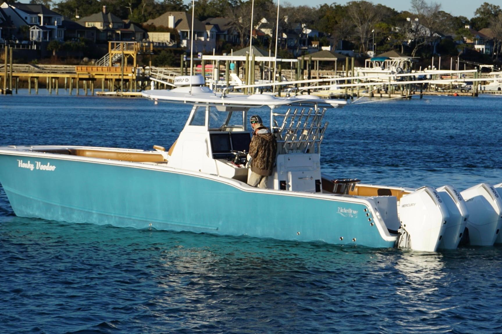 2022 Tideline 365 Offshore boat on water near docks and houses.