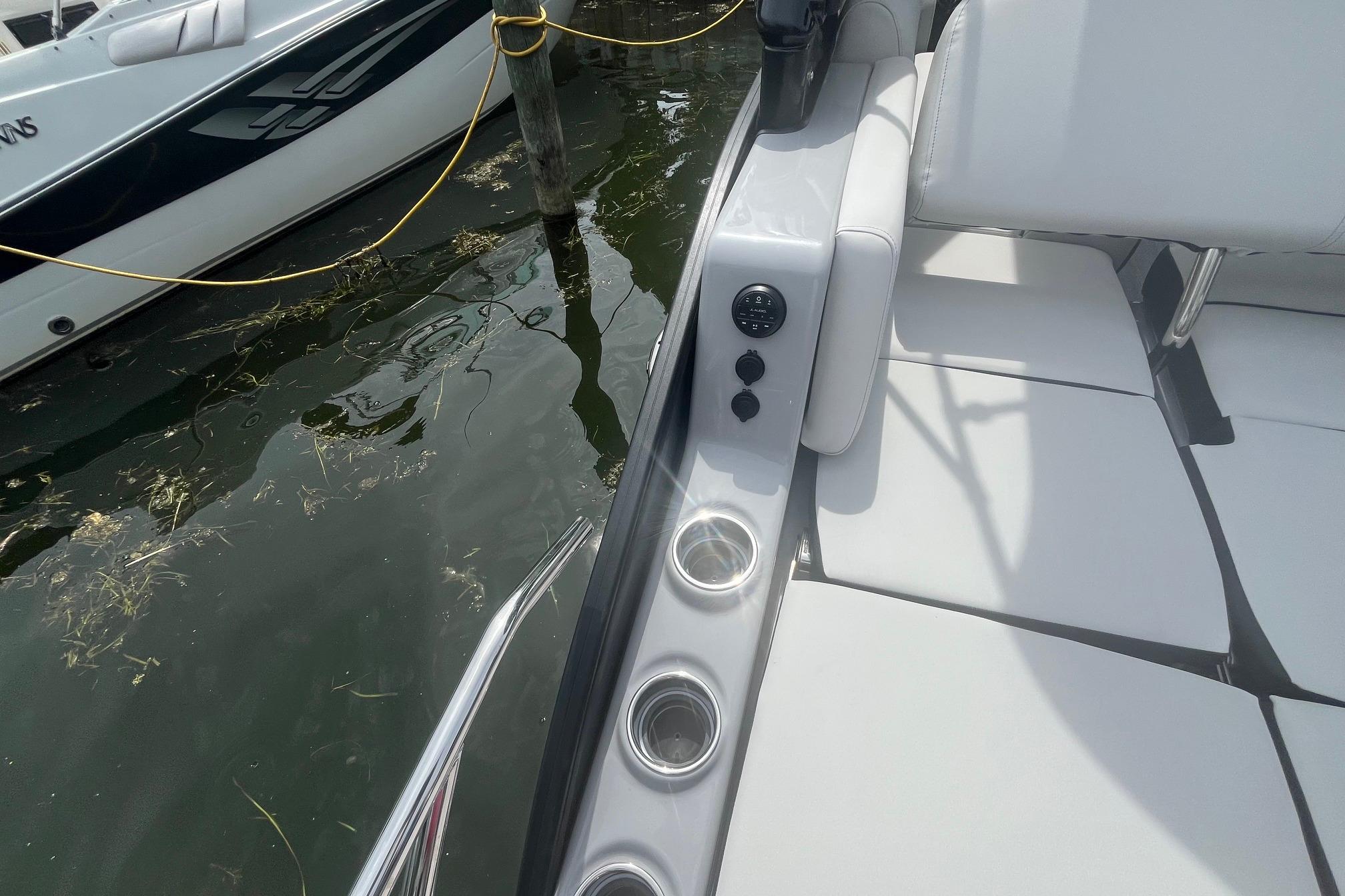 2024 Harris Grand Mariner 250 boat interior with white seating and cup holders.