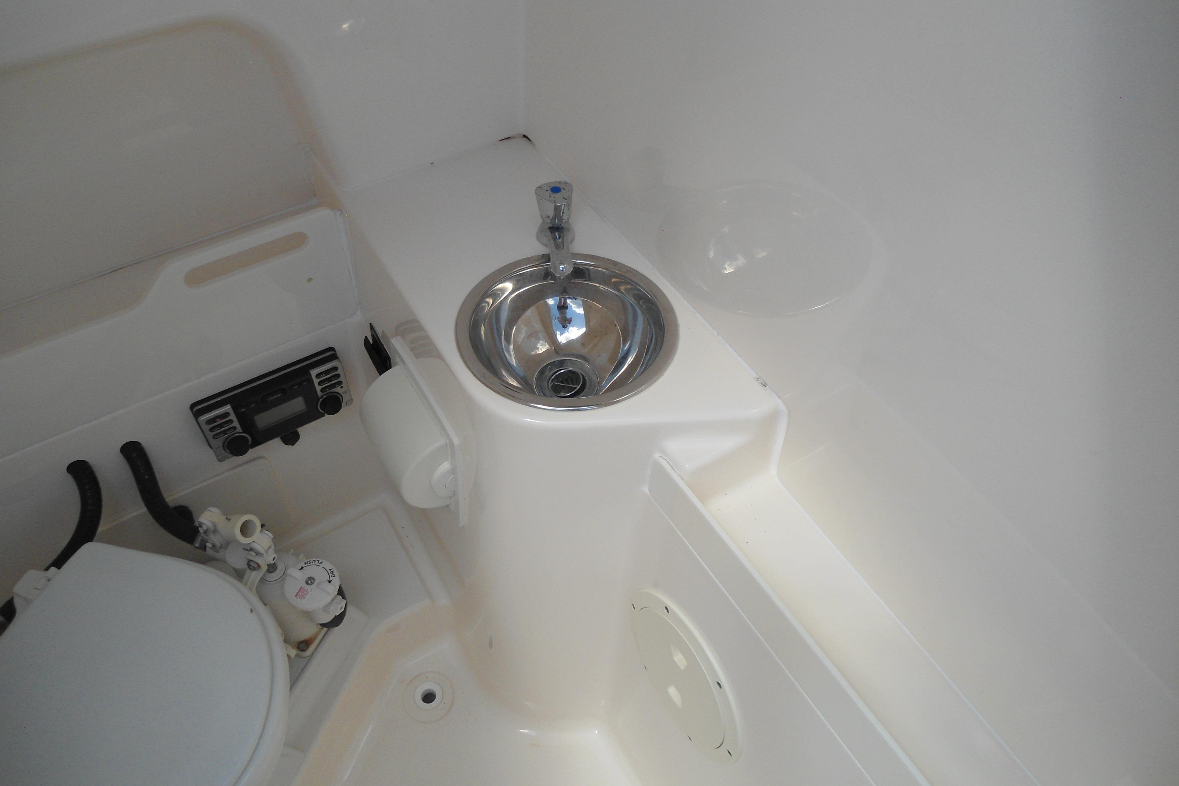 2013 Pursuit C 260 Center Console boat interior with sink and toilet.