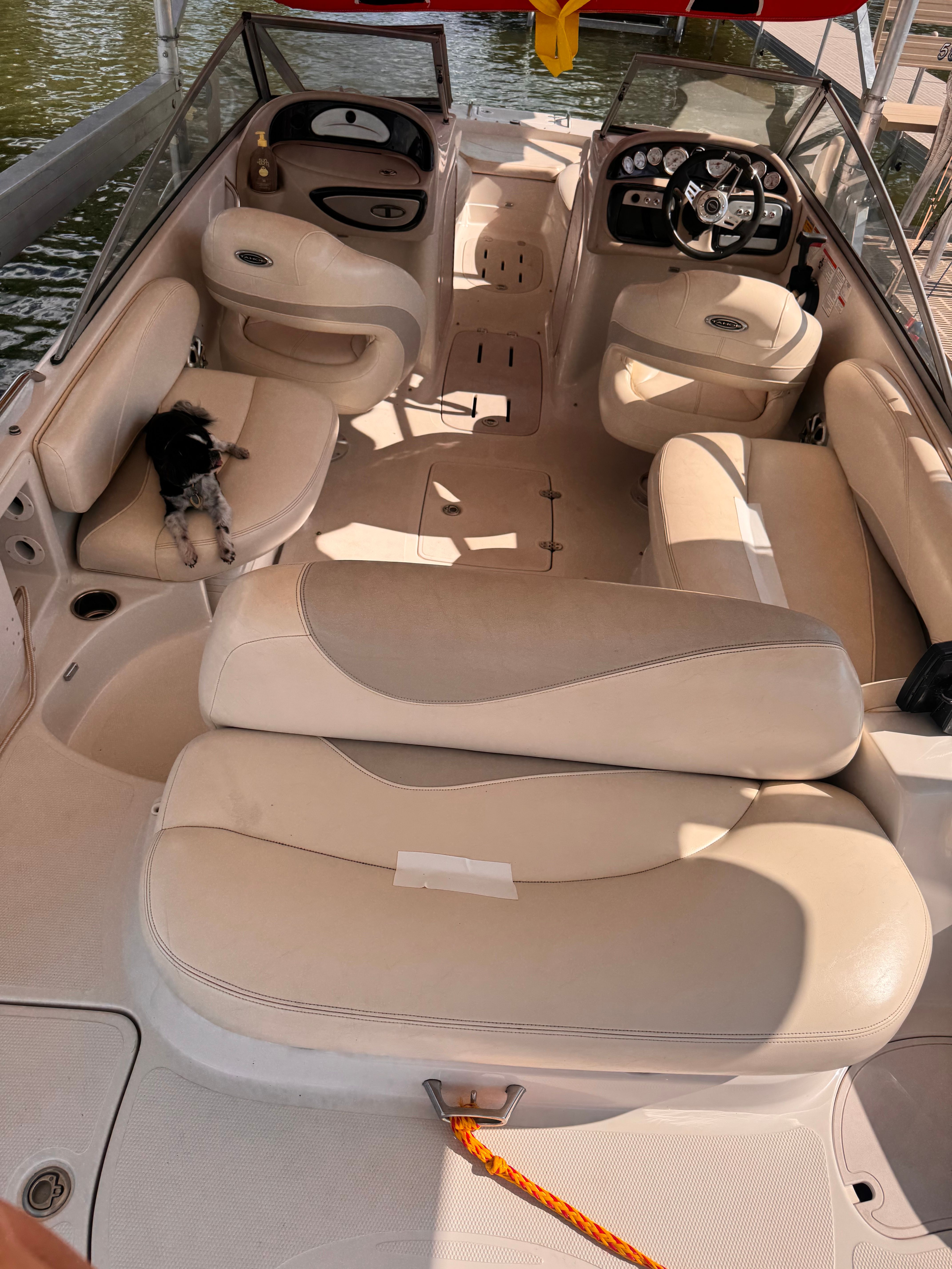 The image shows the interior of a 2011 Tahoe 228 boat with beige seating and a helm station.