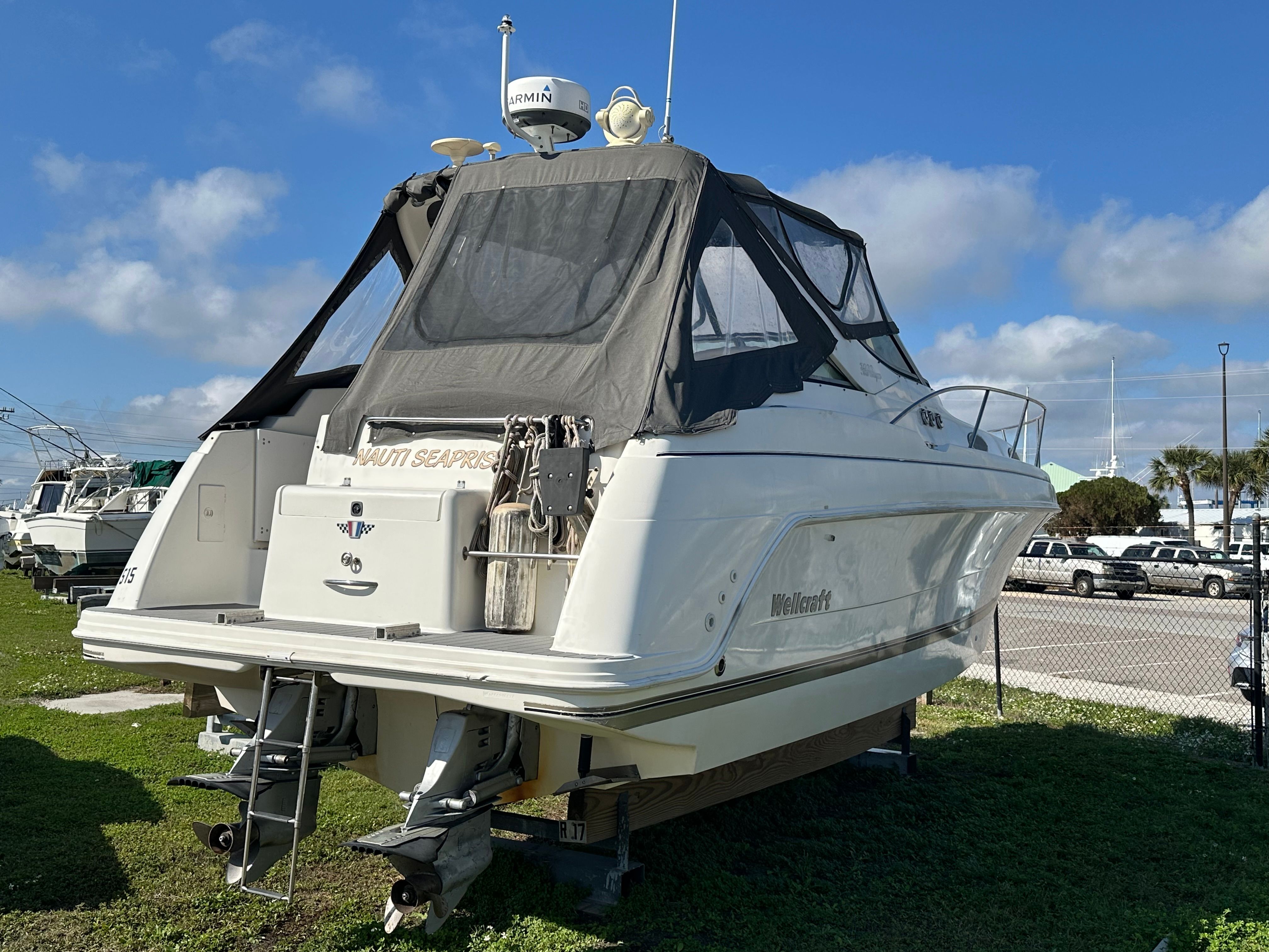 1999 Wellcraft 3000 Martinique boat parked on grass.