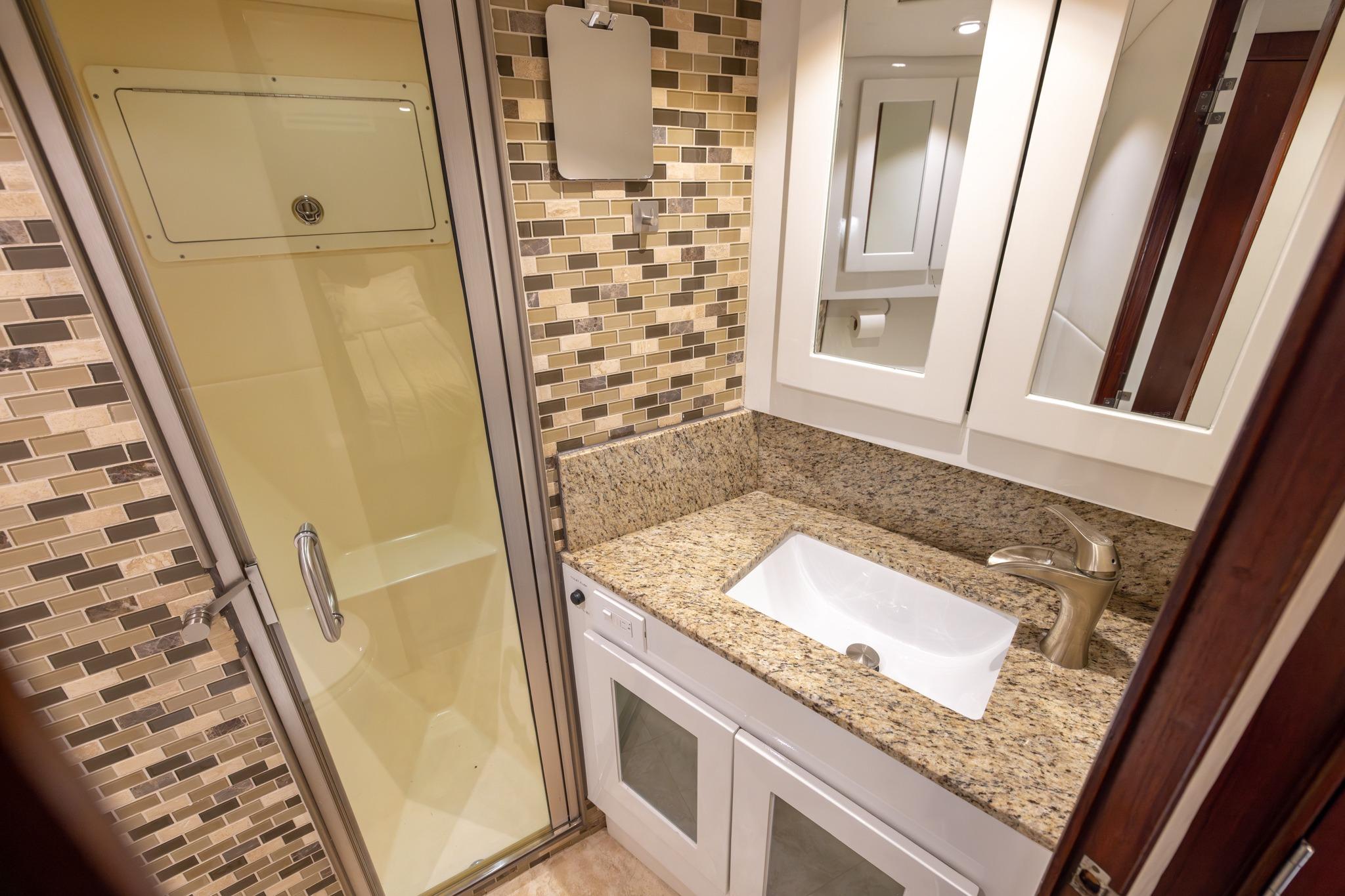 Luxurious bathroom in 1984 Ocean Yachts 55 Super Sport with granite countertop and modern shower.
