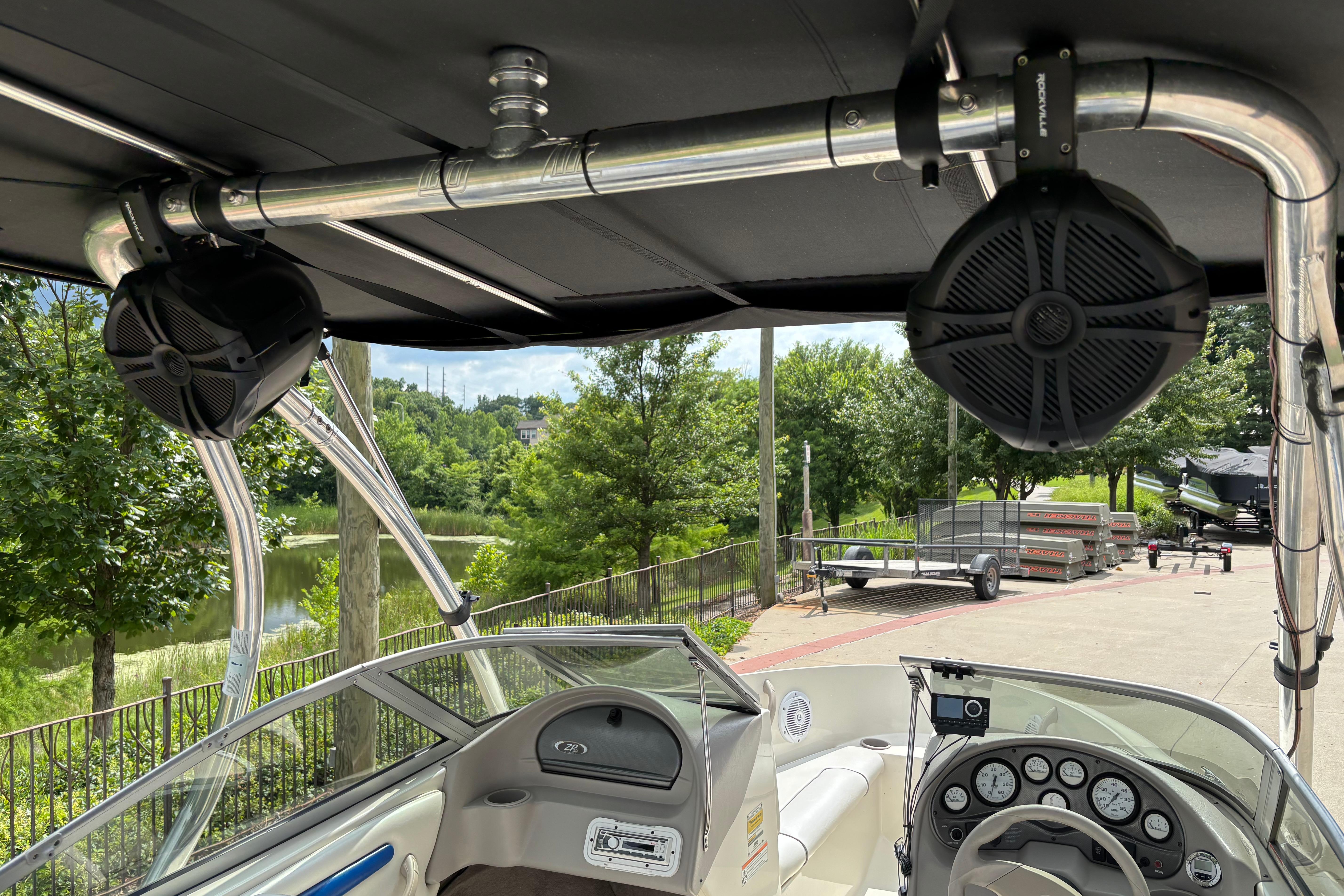 2007 Stingray 180 RX boat interior with speakers and dashboard, parked near a scenic lake.