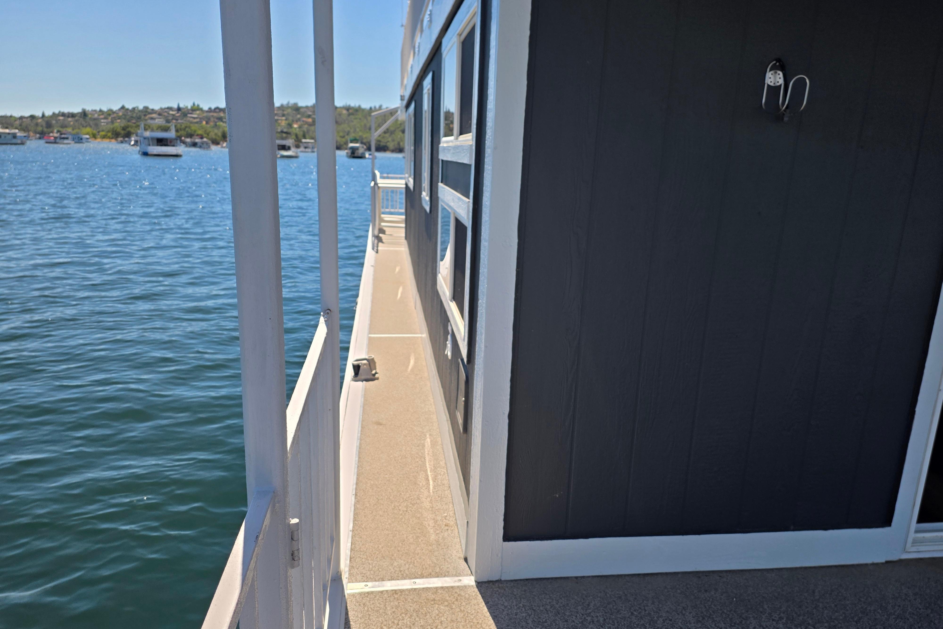 Side view of a 2007 custom houseboat on a serene lake.