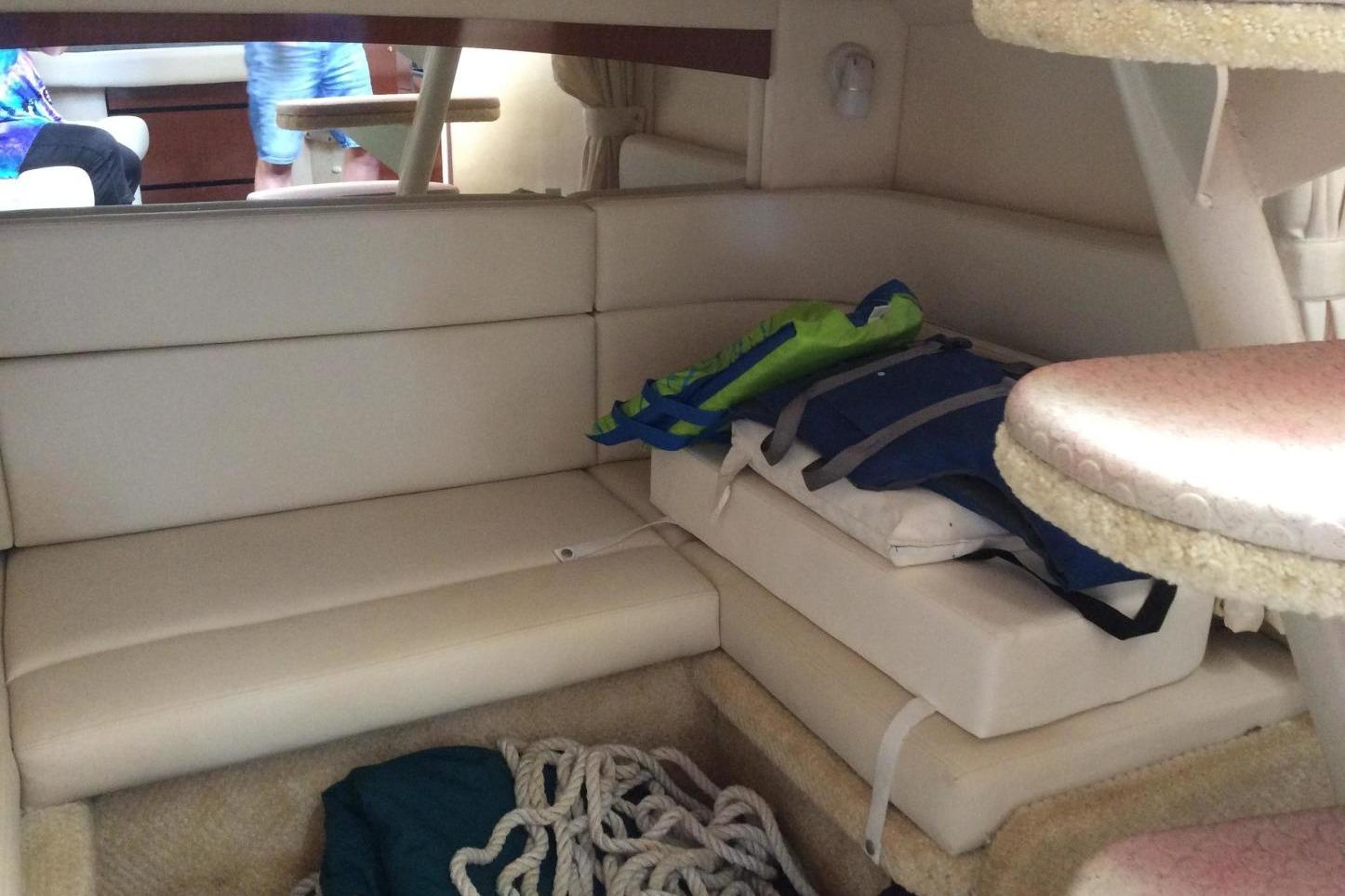 Interior of 2003 Sea Ray 320 Sundancer with seating, life jackets, and rope storage.