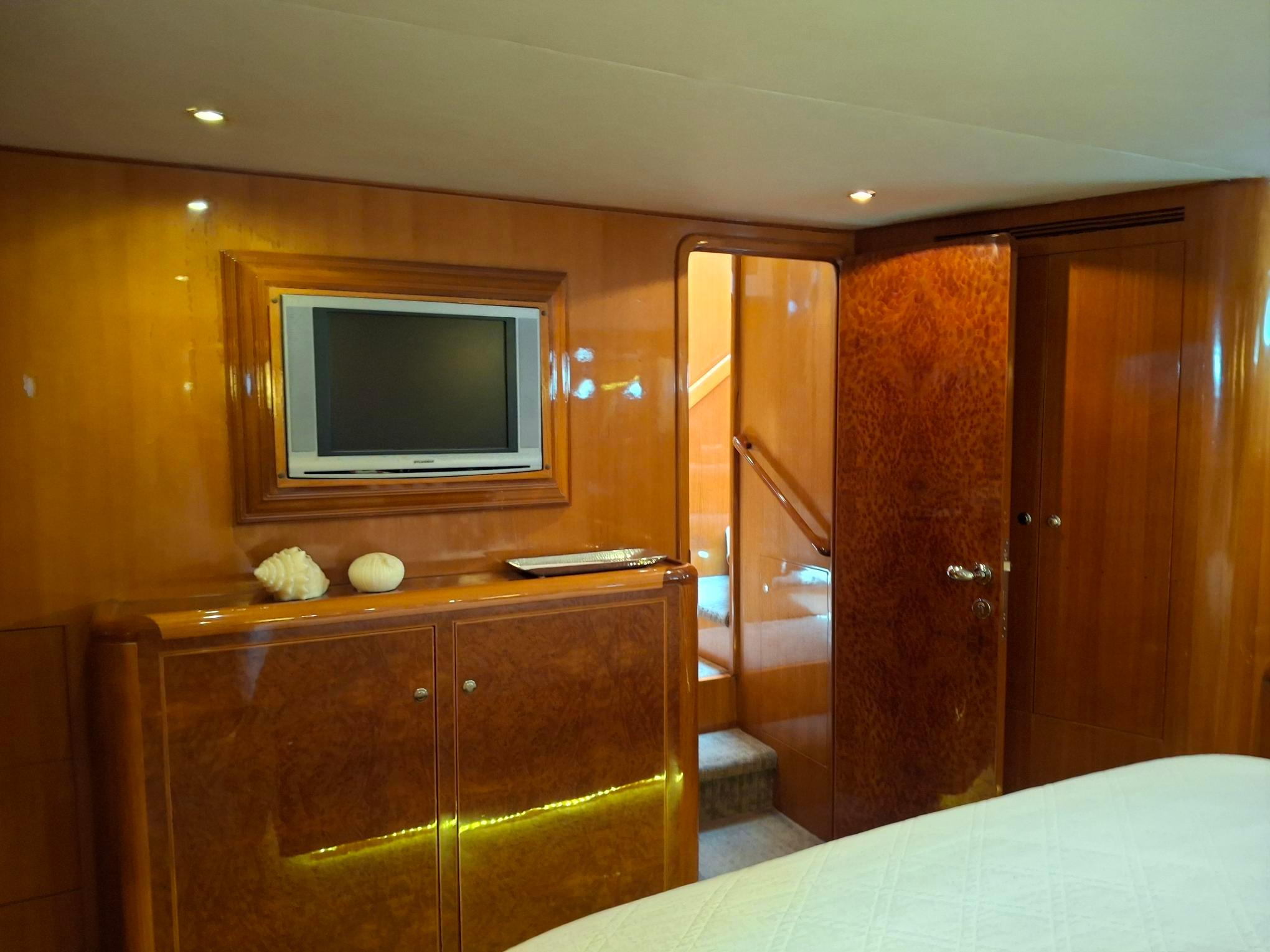 Luxurious interior of 2004 Ocean Alexander 64 Pilothouse yacht with wood paneling and TV.